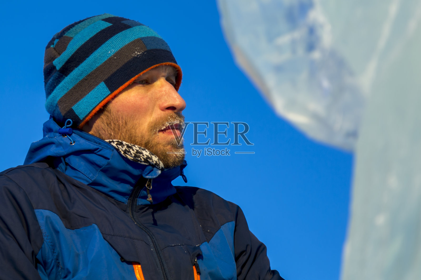 一名建筑工人的肖像，穿着蓝色的针织帽和蓝色的冬季夹克照片摄影图片