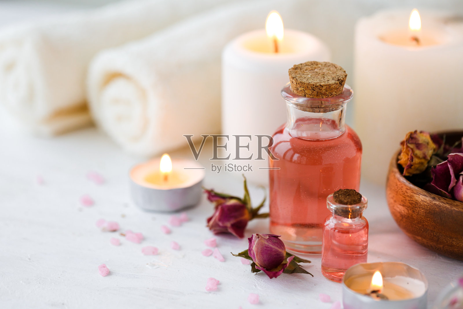 沙龙水疗的概念。天然有机油、毛巾、蜡烛装饰。放松、宁静和愉快的气氛。抗压力和排毒程序。奢侈的生活方式。白色木制背景照片摄影图片