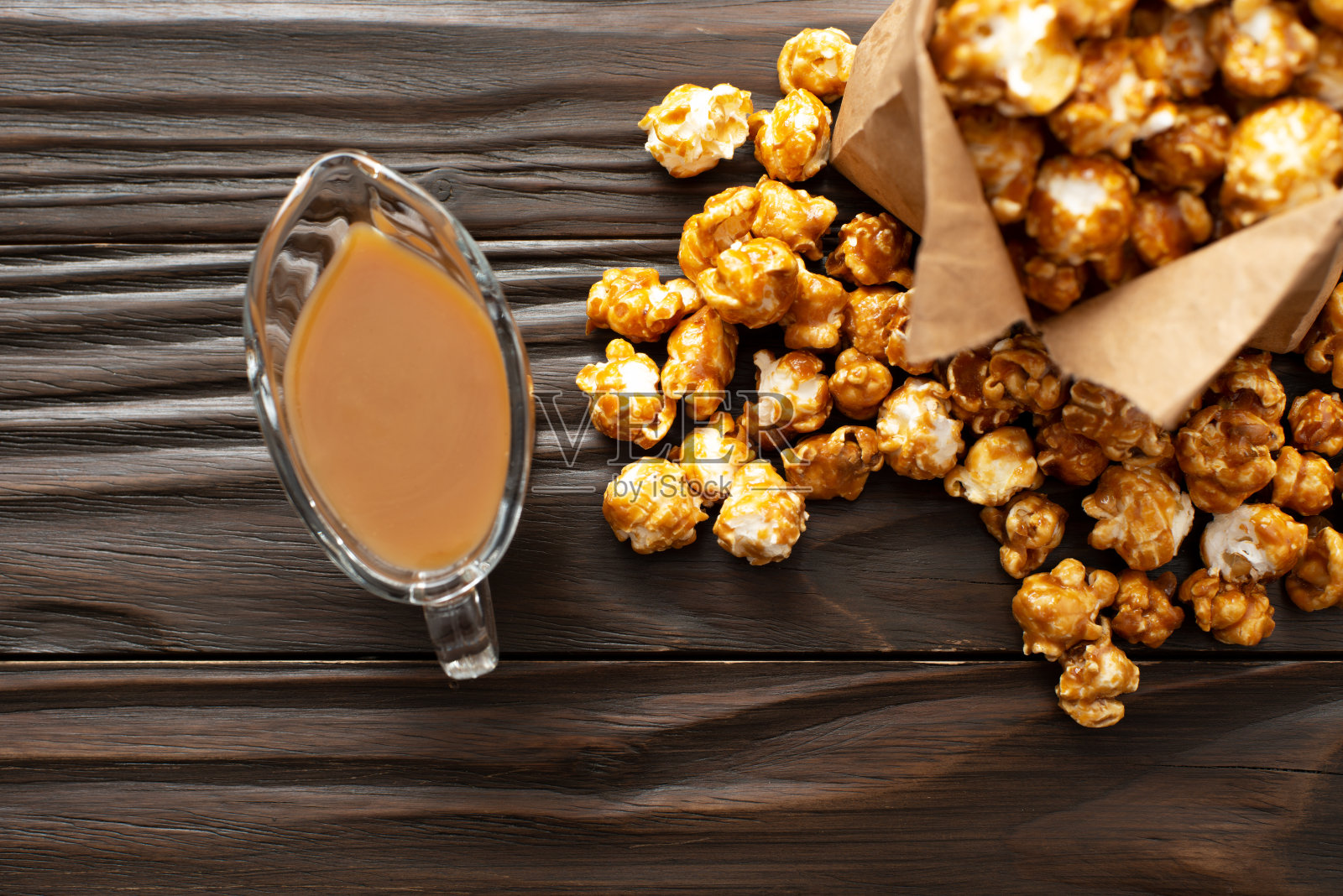 焦糖爆米花装在纸袋里，平放在厨房的木桌上照片摄影图片