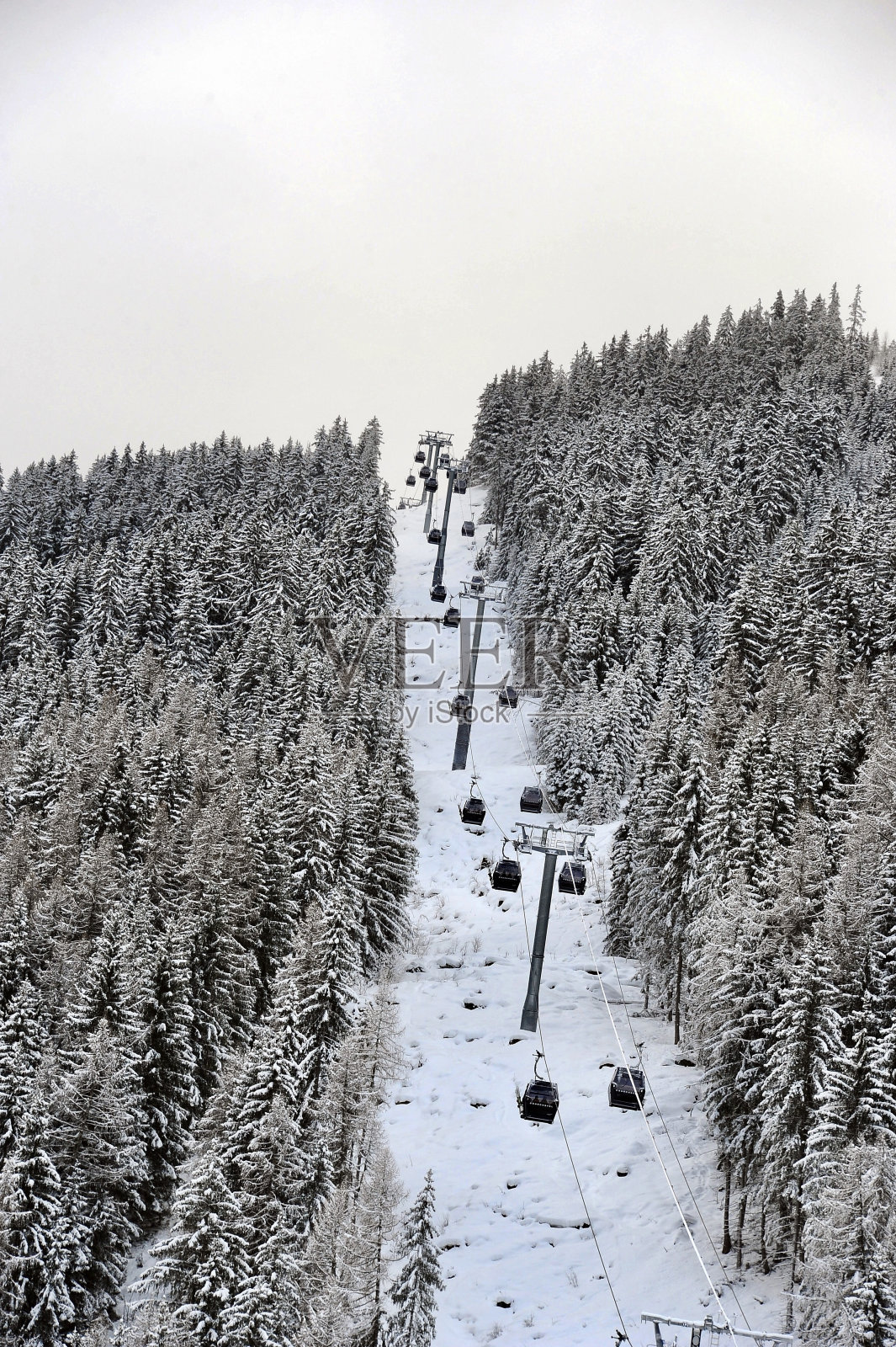 在法国阿尔卑斯的库尔舍维尔滑雪场，滑雪电梯在雪山森林之间的山。照片摄影图片