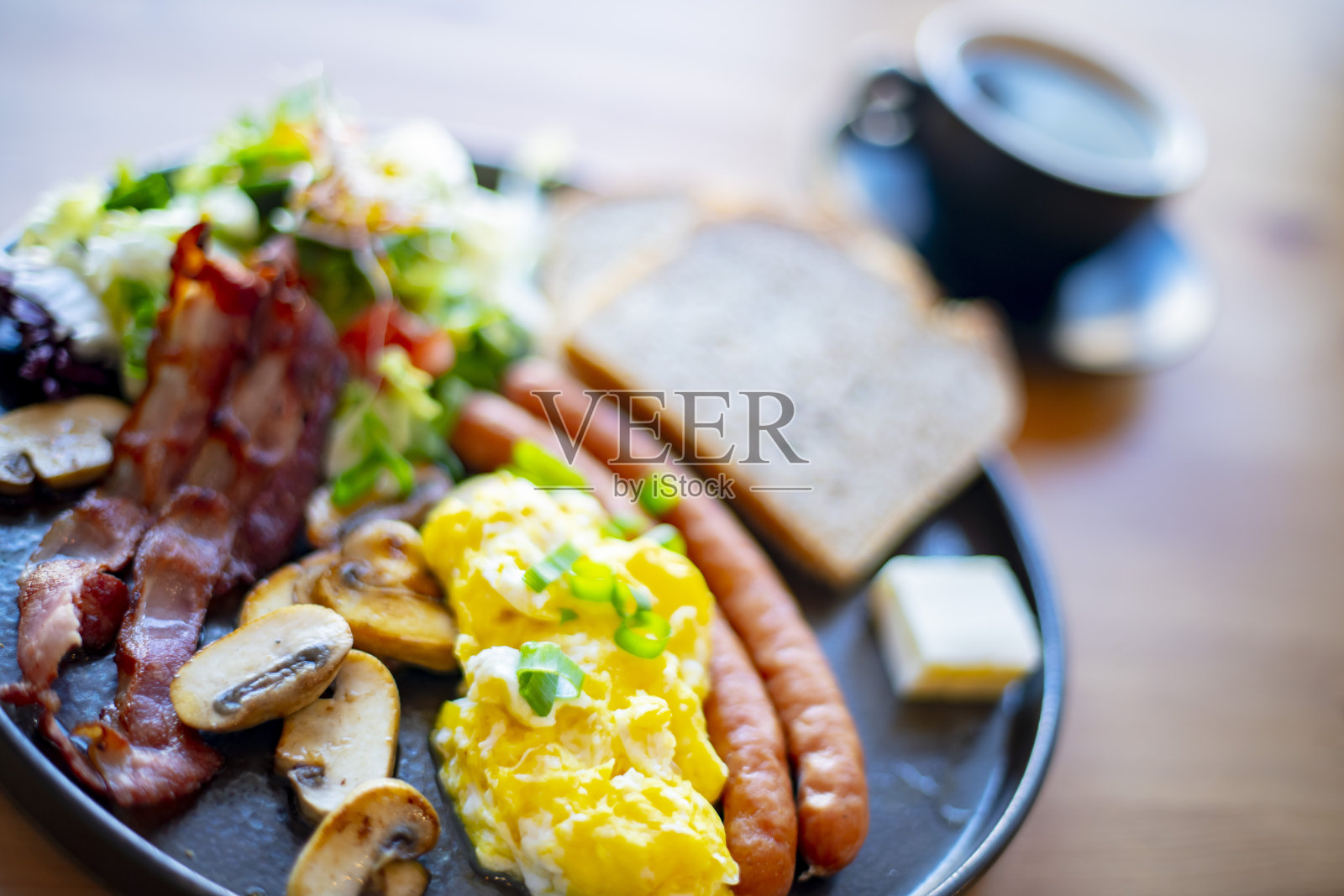 早餐有炒鸡蛋、培根、香肠和吐司照片摄影图片