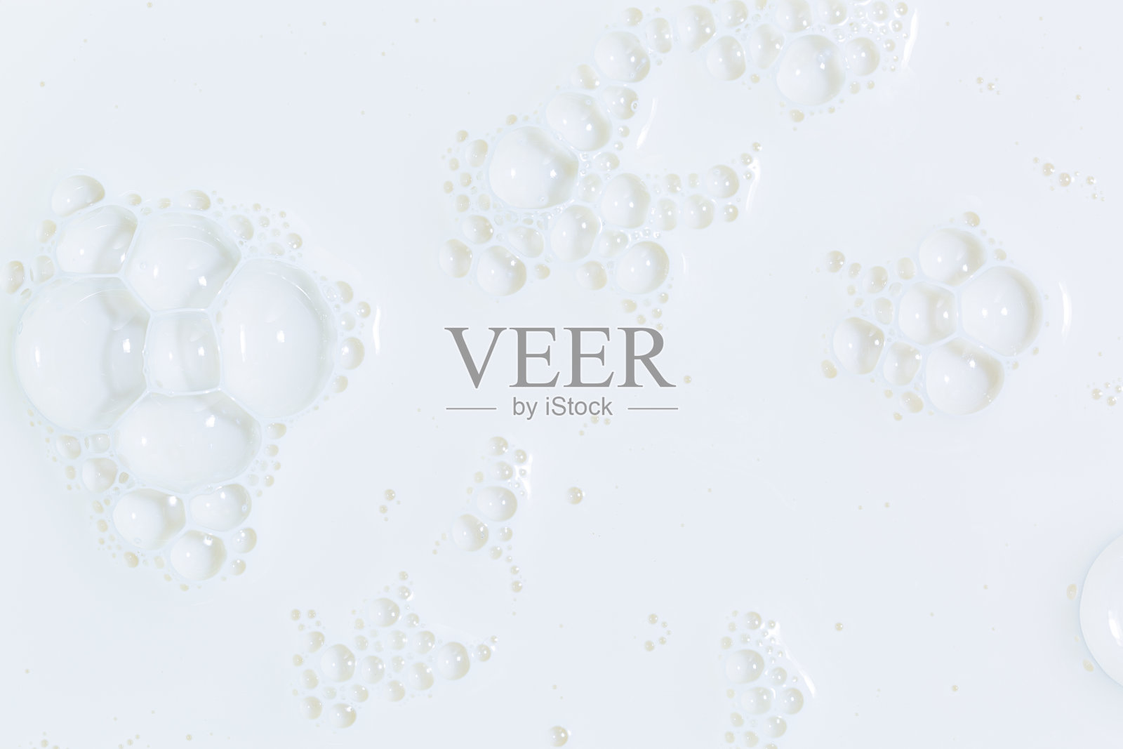 宏观牛奶，白色的牛奶表面和泡沫和涟漪从上面鸟瞰，泡沫在牛奶表面照片摄影图片