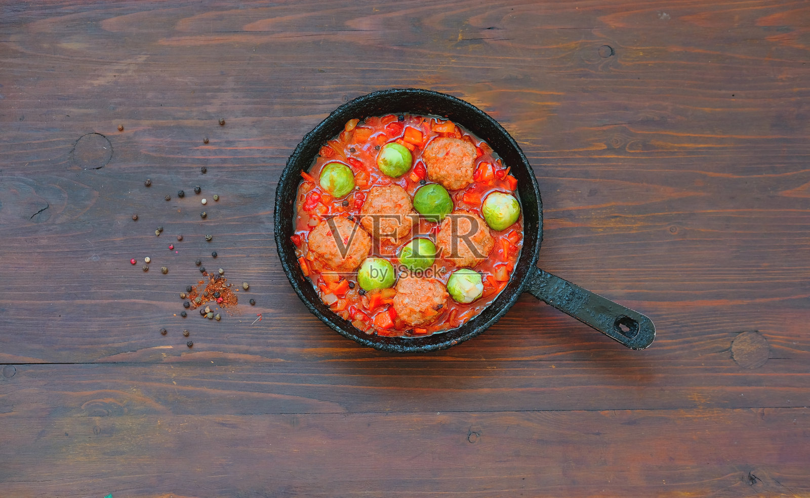 在木制背景的正宗煎锅里放上椰菜和番茄酱。照片摄影图片