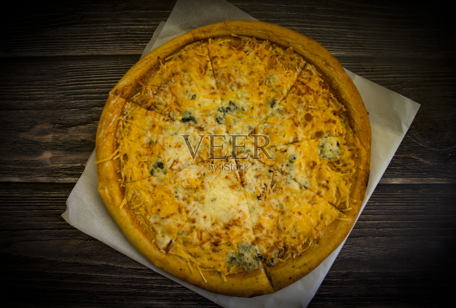 旧木制背景上的奶酪披萨照片摄影图片