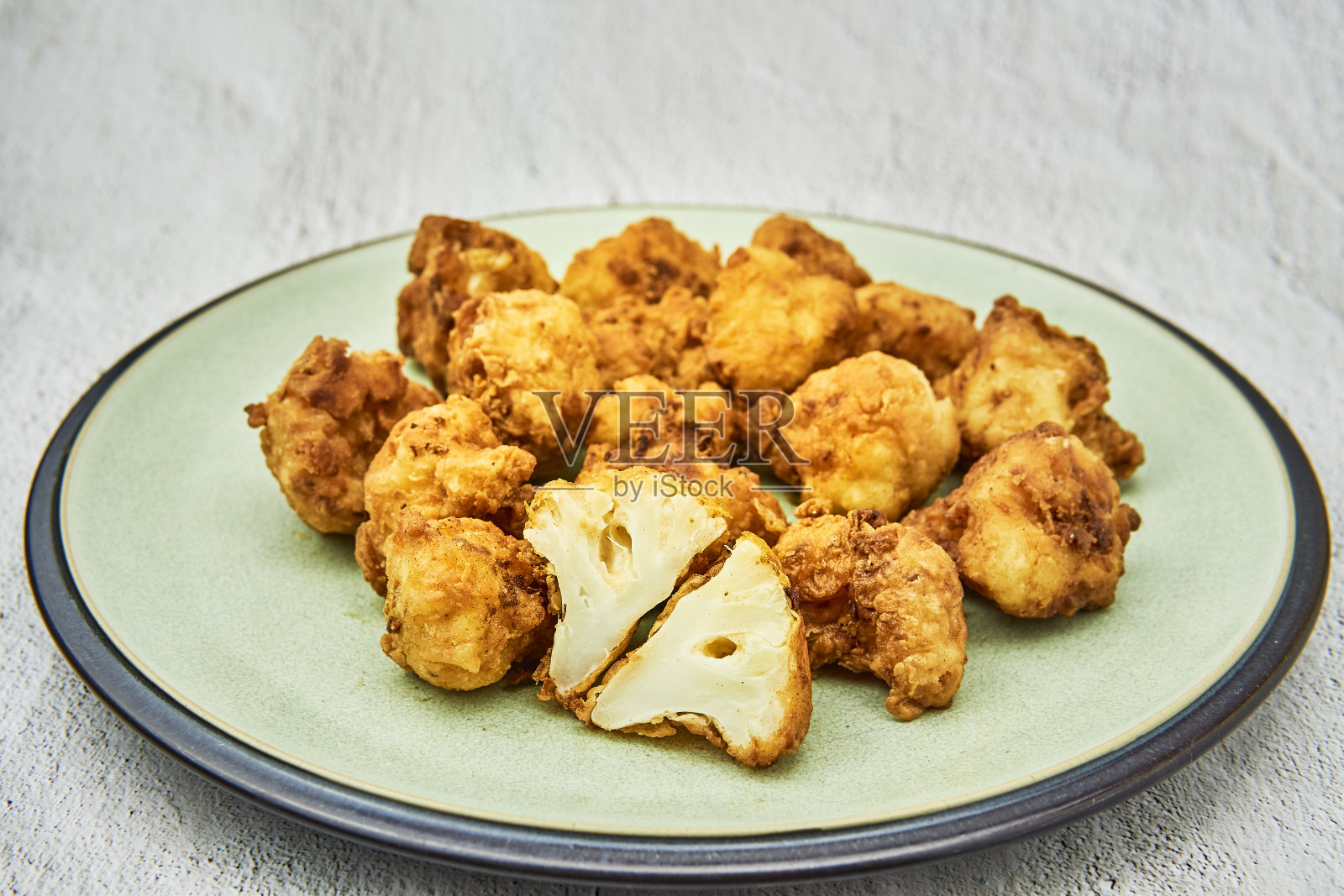 白木桌上的素食花椰菜鸡翅。美味的素食俯视图。油炸花椰菜照片摄影图片