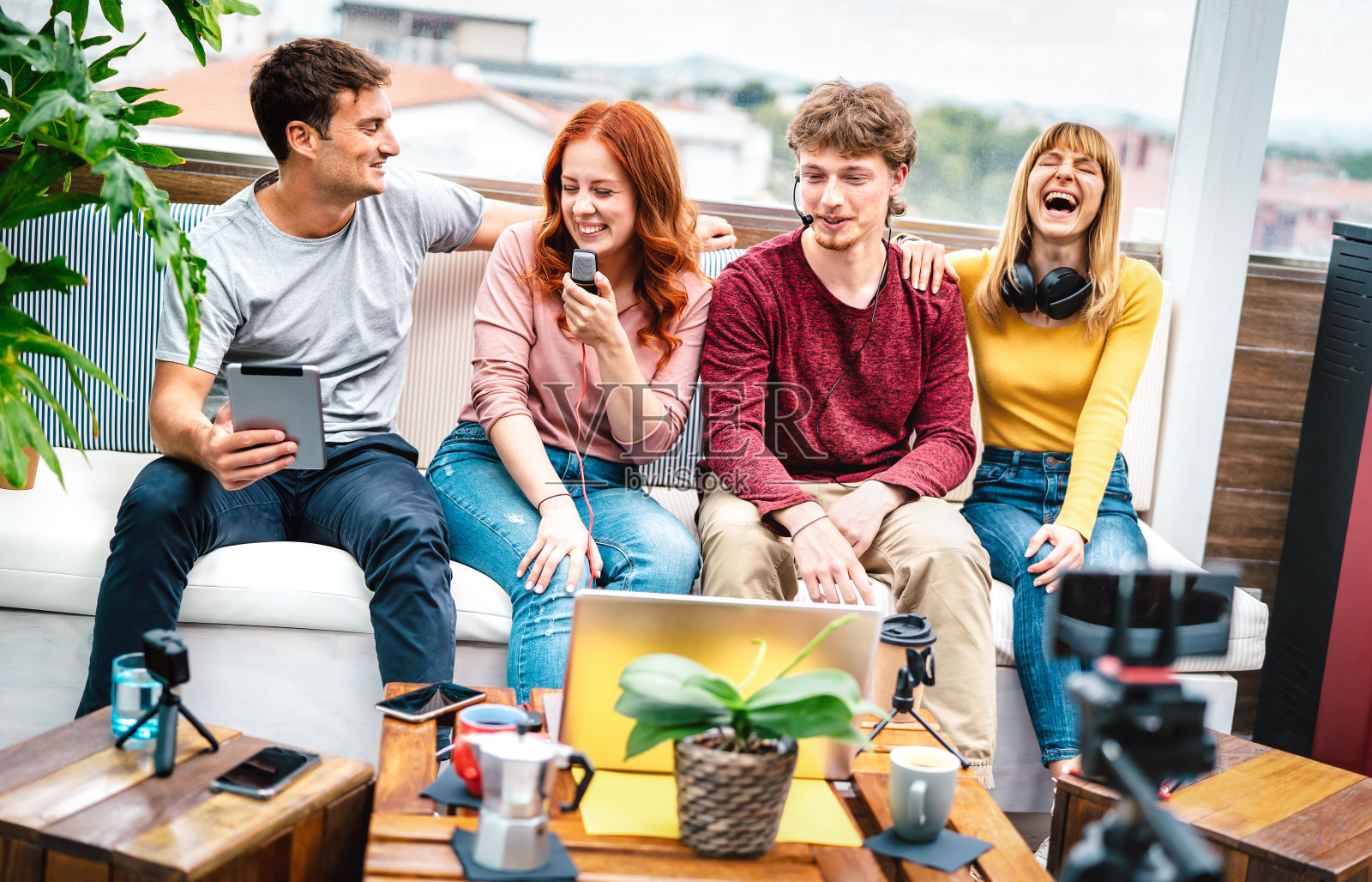 新潮的千禧一代在网络摄像头的流媒体平台上玩得很开心-内容营销概念与千禧一代的男孩和女孩在现代开放空间办公室分享直播视频日志-明亮生动的过滤器照片摄影图片