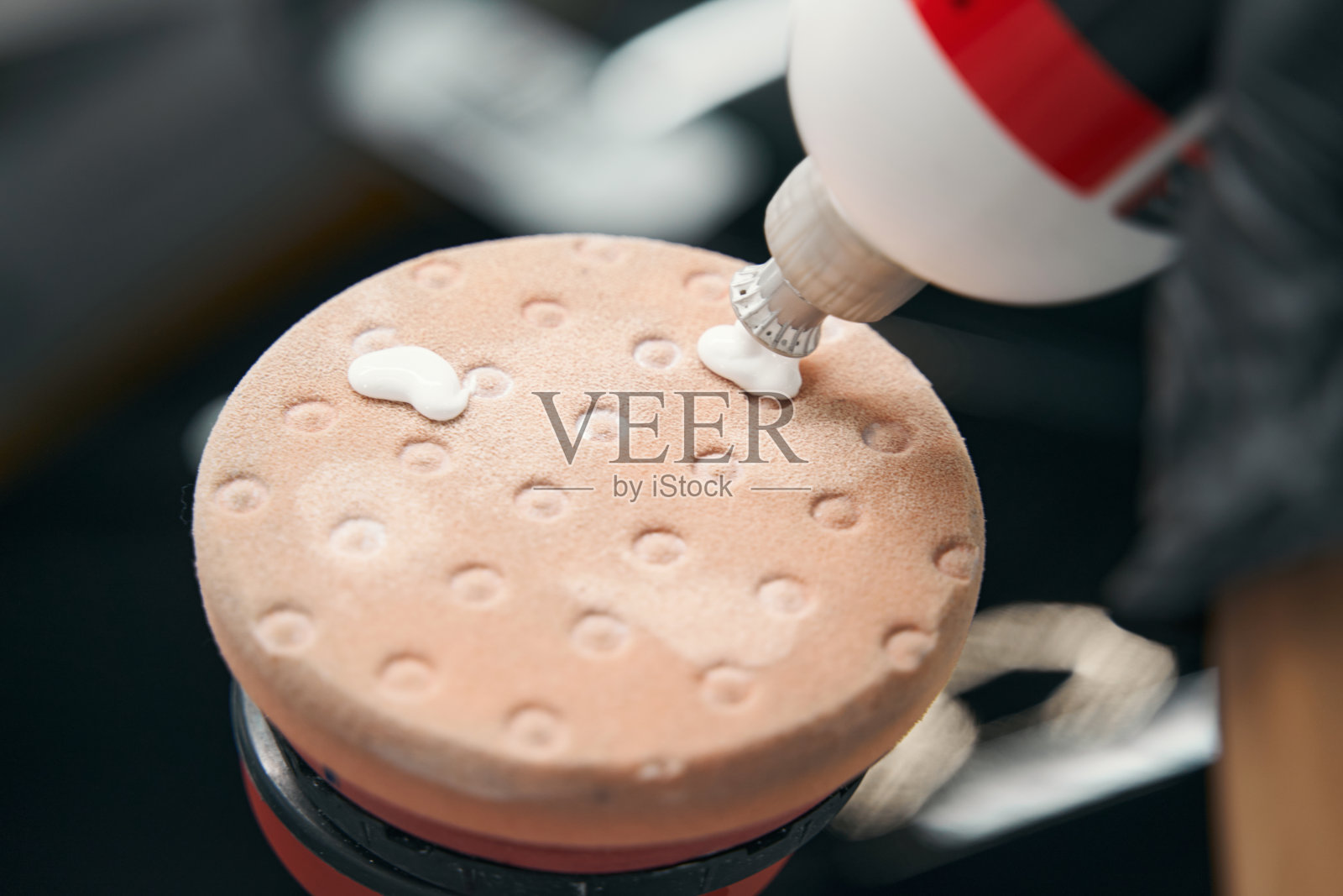 工人在抛光头上挤出抛光剂照片摄影图片