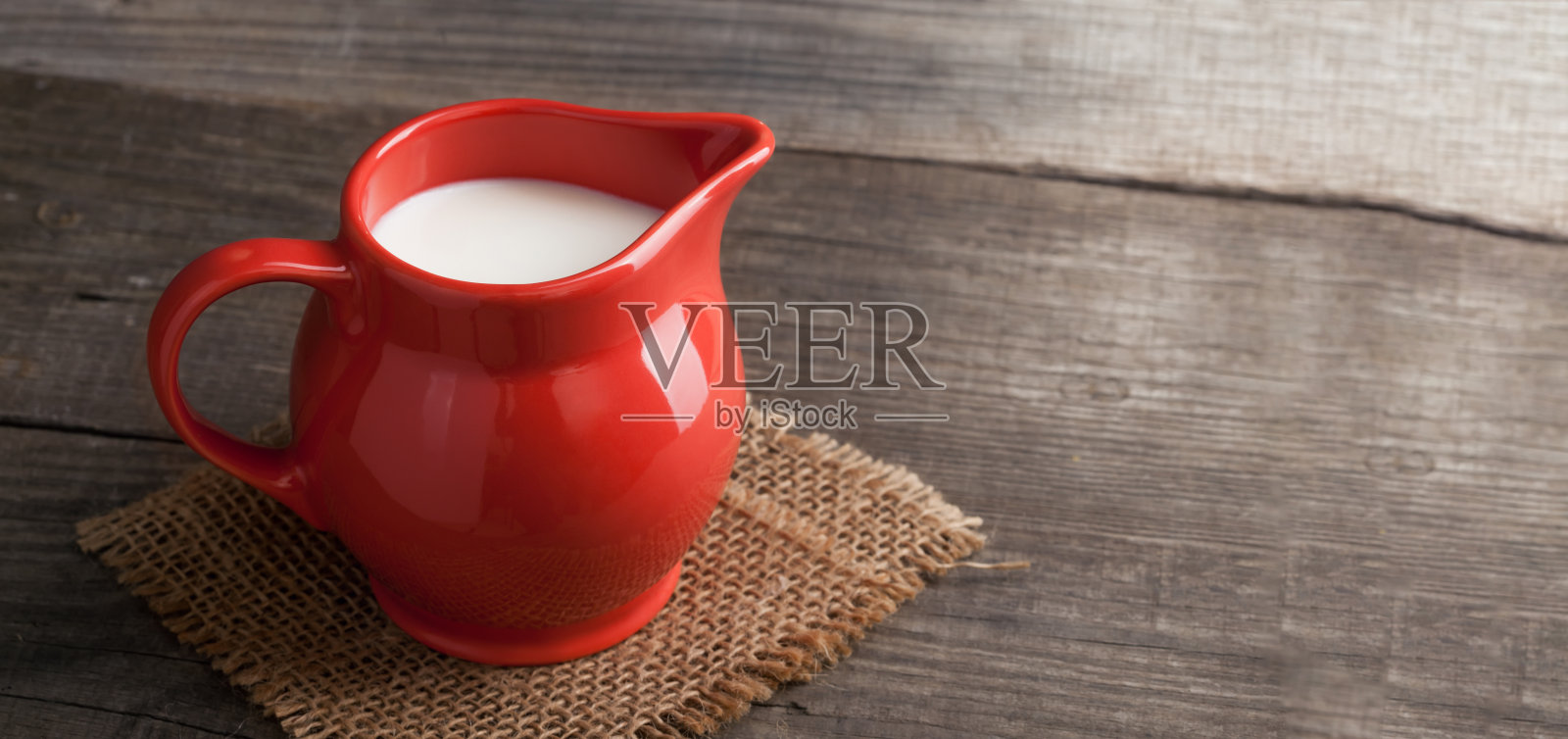 牛奶在白色背景木制桌子上的玻璃水罐照片摄影图片