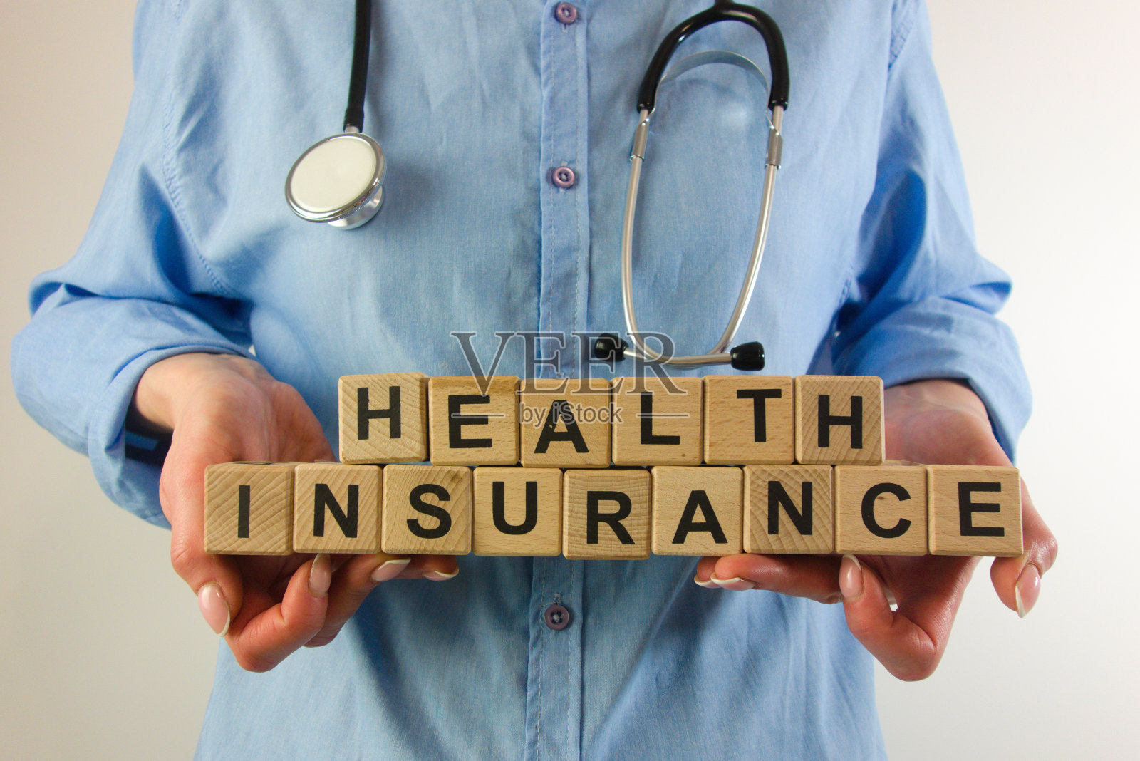 女医生手持健康保险木块的文字照片摄影图片