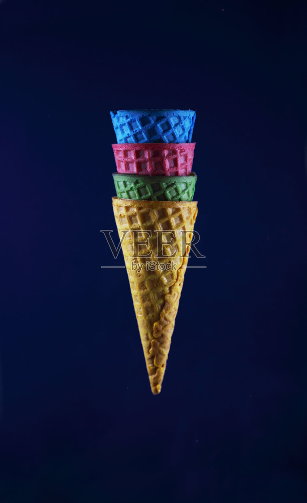 4个不同颜色的华夫饼，在蓝色的背景下孤立起来照片摄影图片