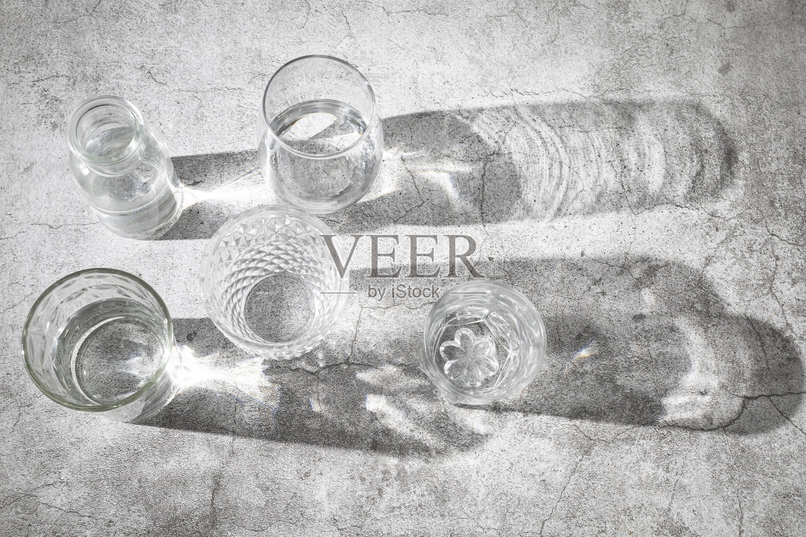 在日光下，水泥背景上的几杯水照片摄影图片