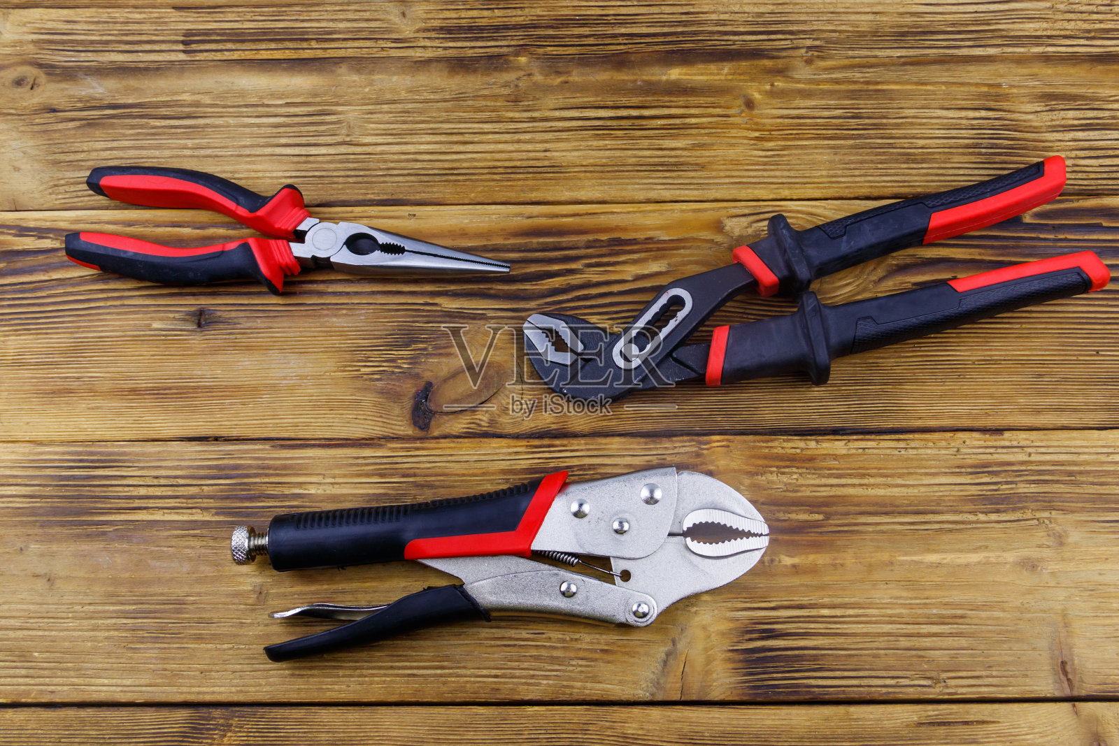 在木制背景上设置不同的钳子。俯视图照片摄影图片