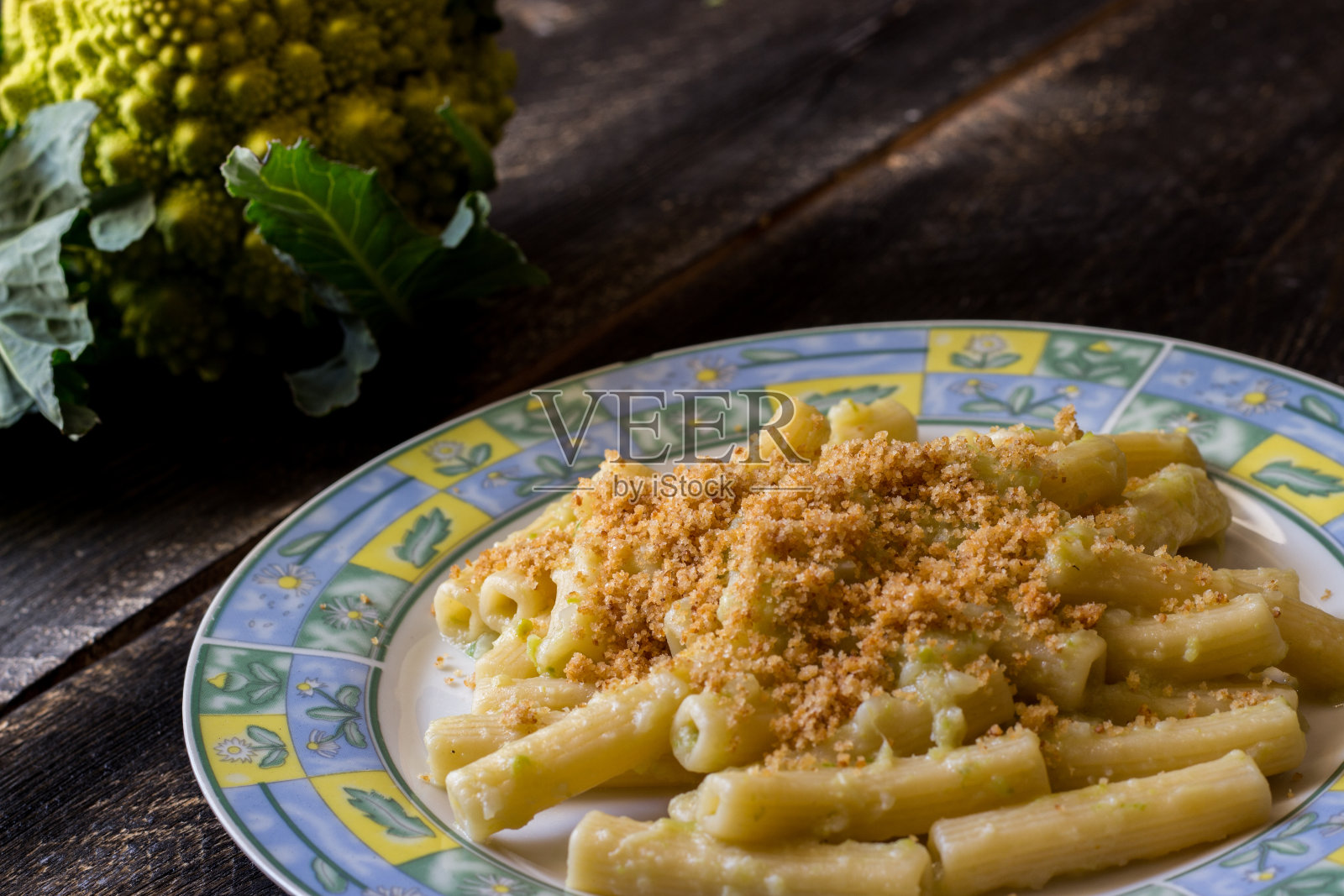 意大利面配有机罗马花椰菜酱，撒上烤面包屑在黑色木质背景上照片摄影图片