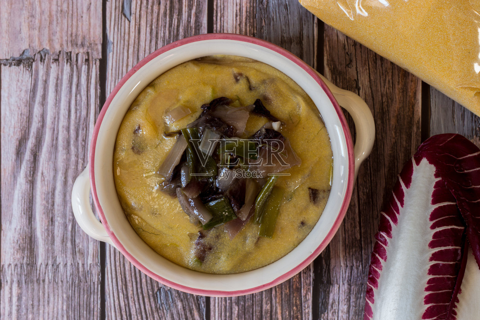 玉米粥配菊苣和有机韭菜。素食食谱。照片摄影图片