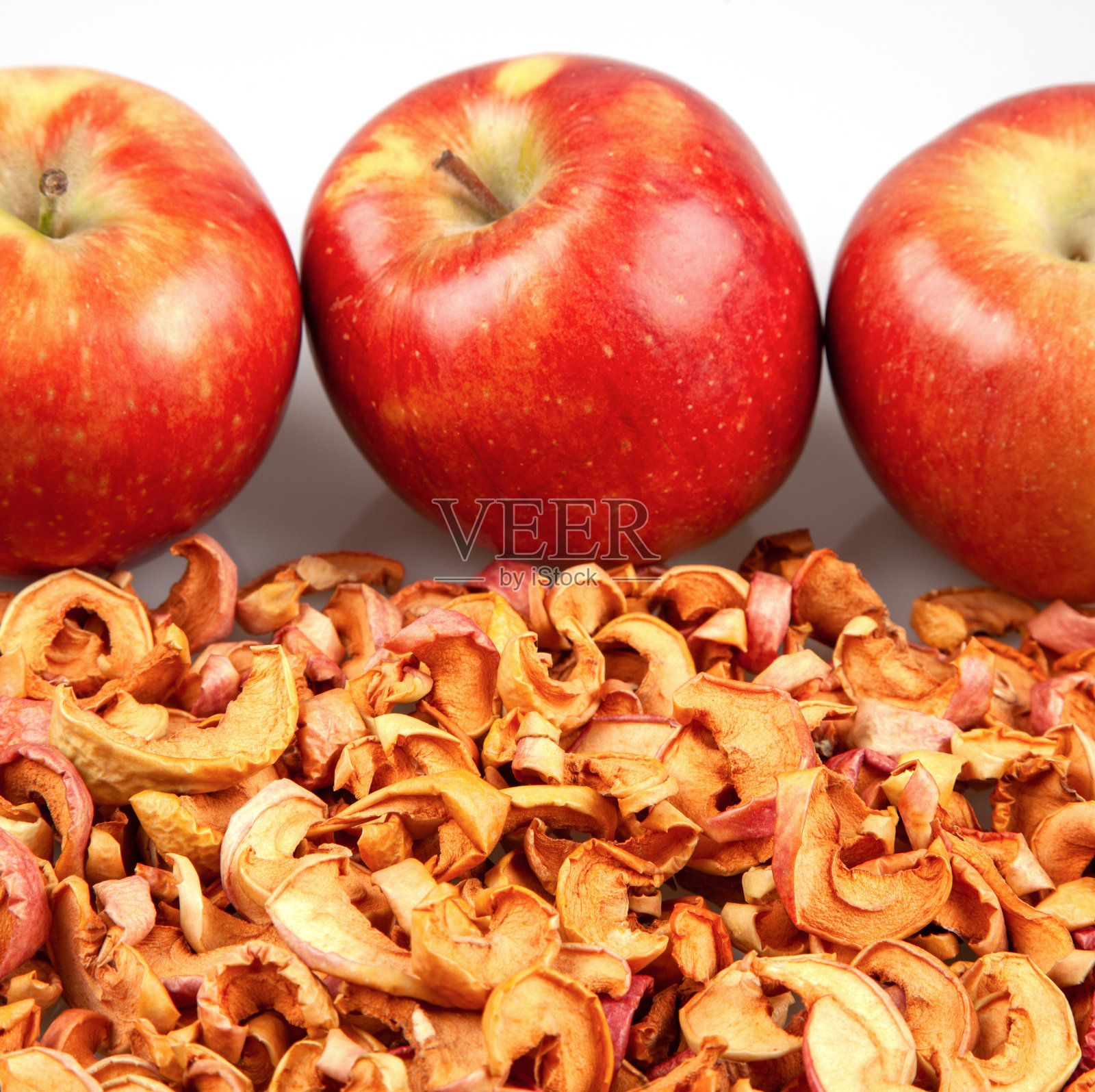 新鲜的红苹果放在干苹果片上照片摄影图片