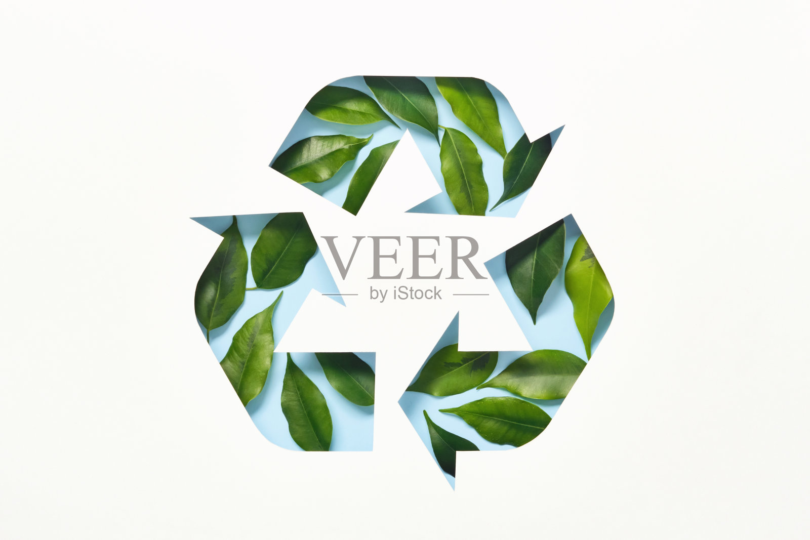 回收标志由剪纸和绿色的叶子在蓝色的背景。重复利用、减少、循环利用的理念照片摄影图片