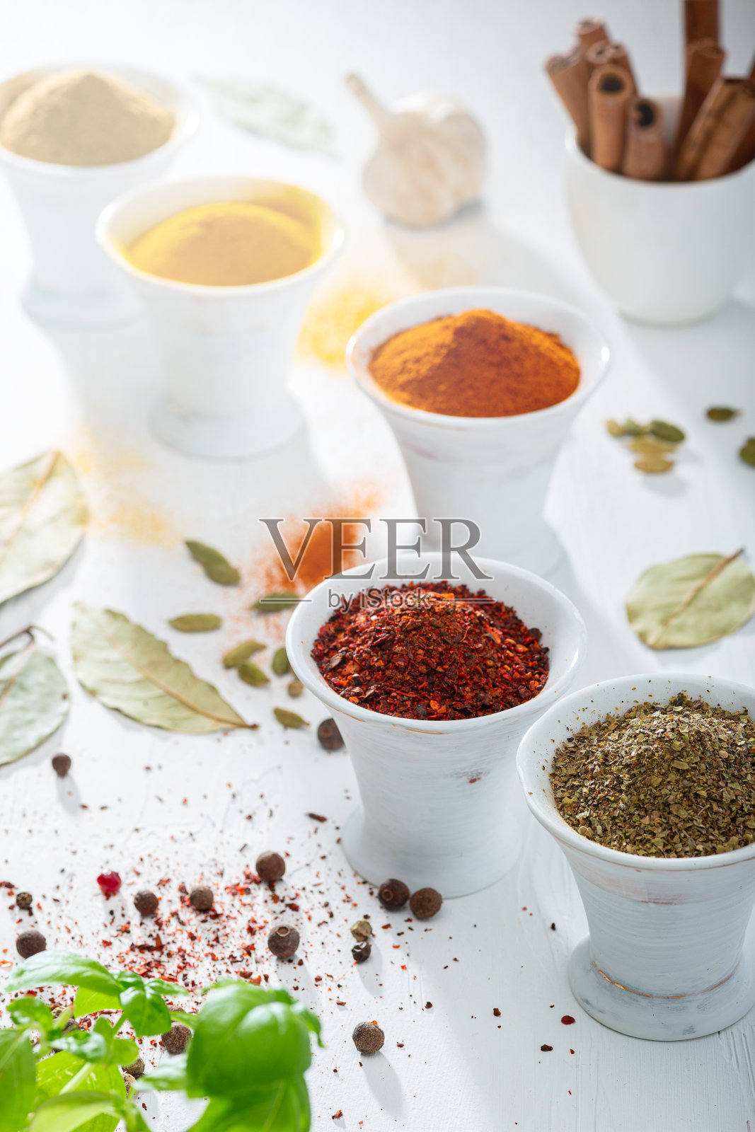 木桌上放着五颜六色的香料。Light.background。照片摄影图片