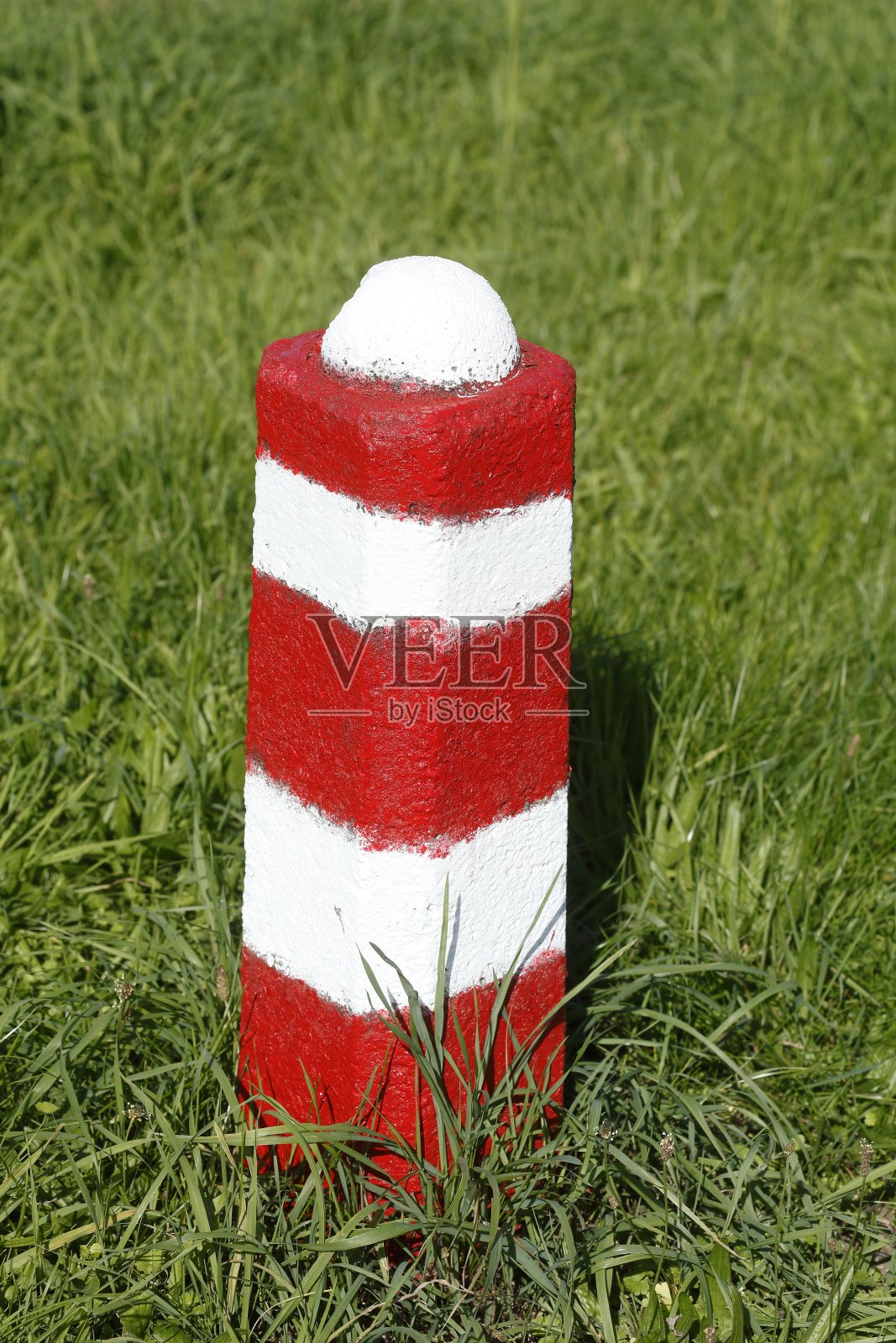 德国，欧洲，草地上的柱子，栅栏柱子，红白相间的石头护柱照片摄影图片