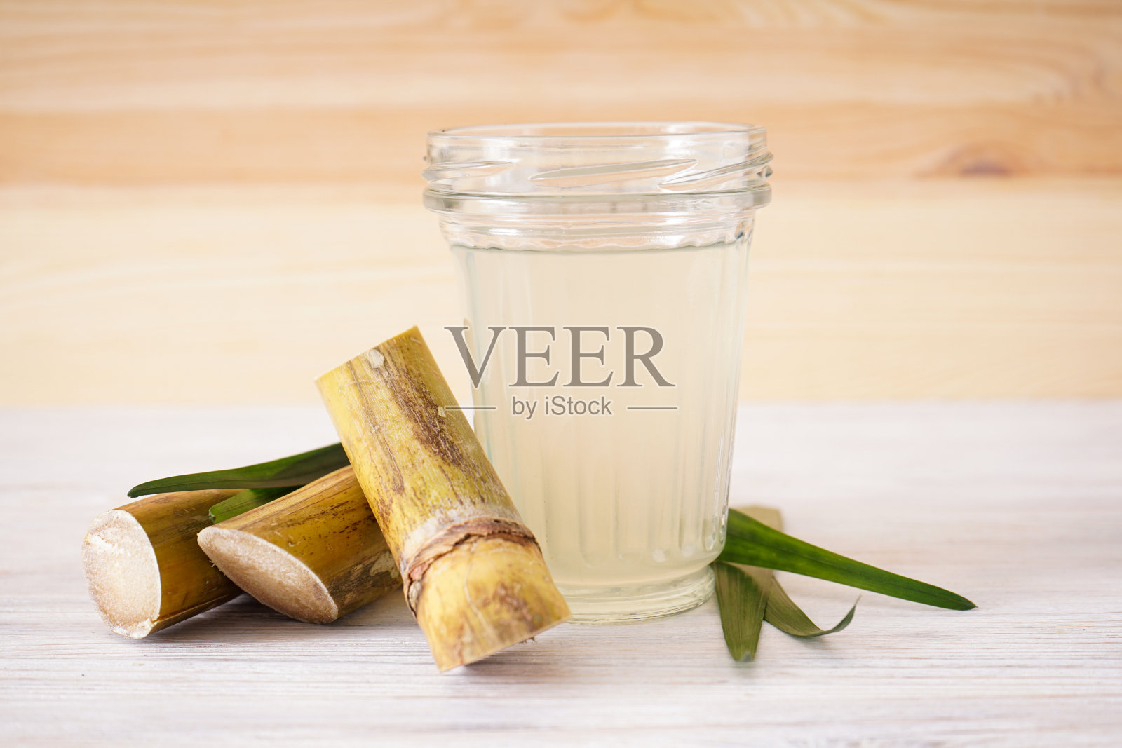 新鲜的甘蔗汁和红糖粒。照片摄影图片