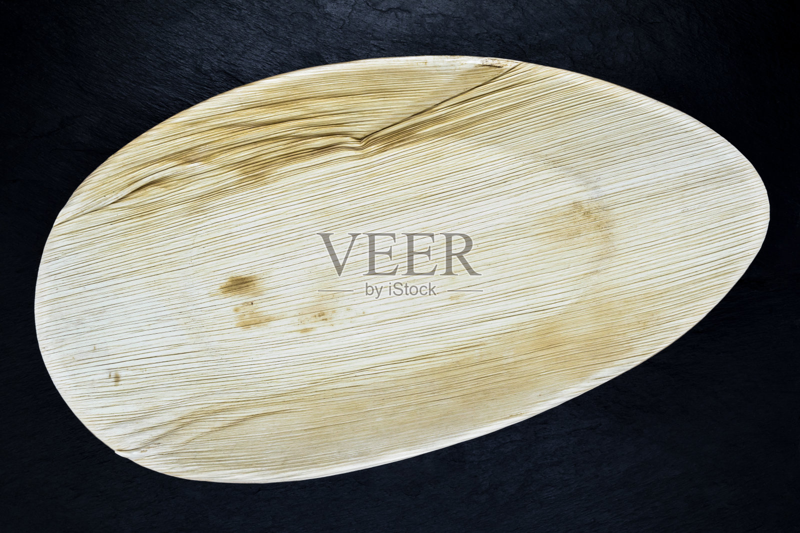 用香蕉叶制成的环保盘子。盘、碟步于黑石背景表面照片摄影图片