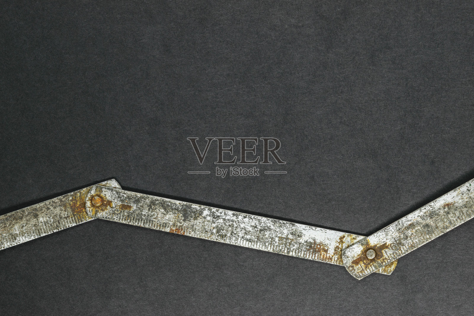 旧的，生锈的金属尺在黑色背景表面与自由空间照片摄影图片