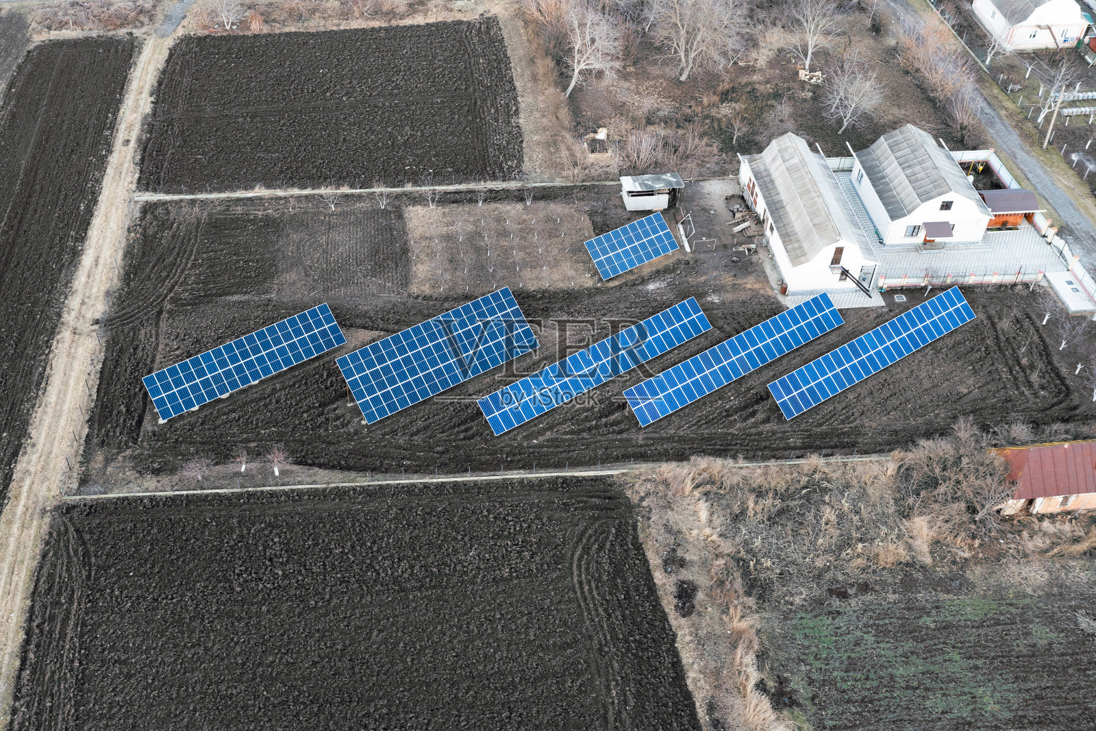 家用太阳能发电厂。太阳能电池板矗立在私人住宅的花园里，鸟瞰图照片摄影图片