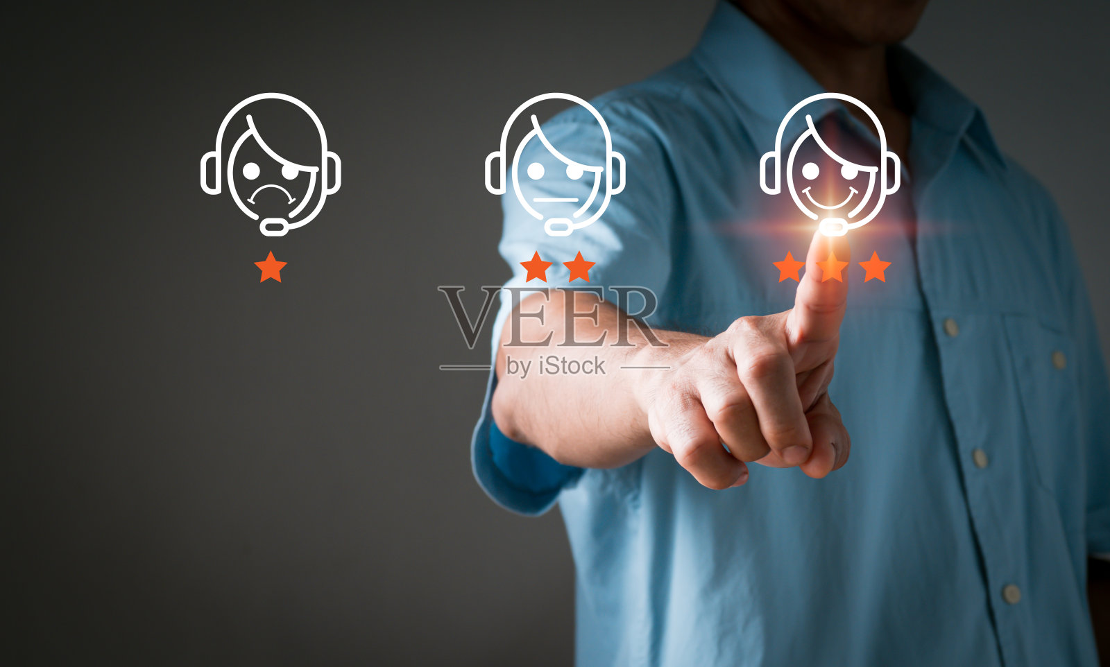 一名男子指着并选择了一个微笑表情符号，显示在虚拟屏幕上。一种调查、民意测验或问卷调查，旨在收集有关用户体验或客户满意度的信息。照片摄影图片