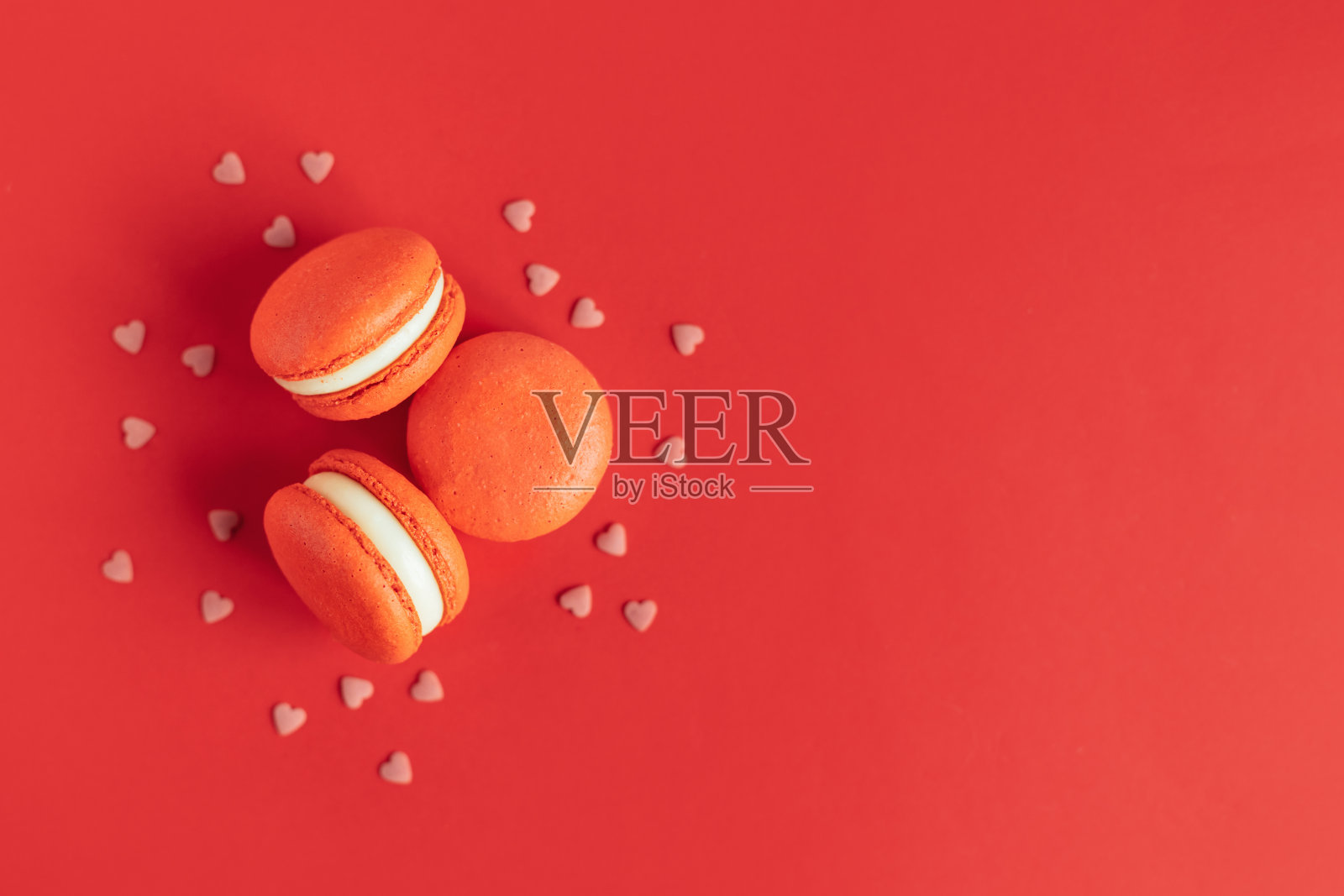 红色背景的美味法式马卡龙。情人节的概念。照片摄影图片