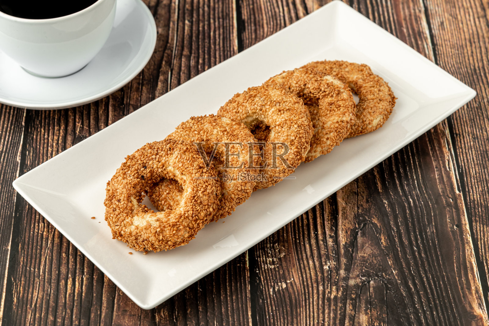 土耳其名字Kandil simidi木桌旁放着茶。土耳其芝麻百吉饼或咸饼干。照片摄影图片