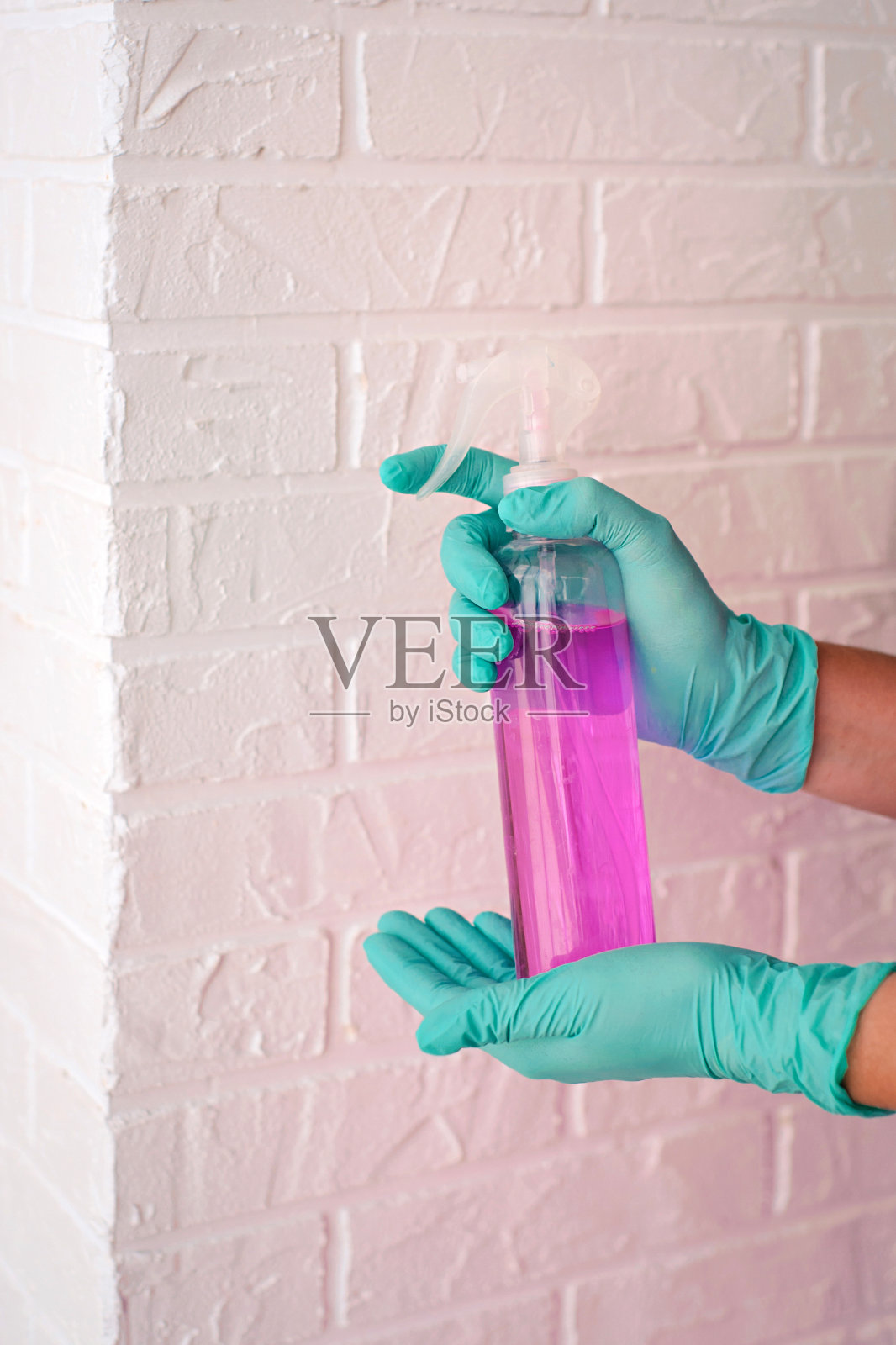手戴着乳胶手套，拿着消毒瓶。抗菌瓶，安全，防疫，清洁理念照片摄影图片