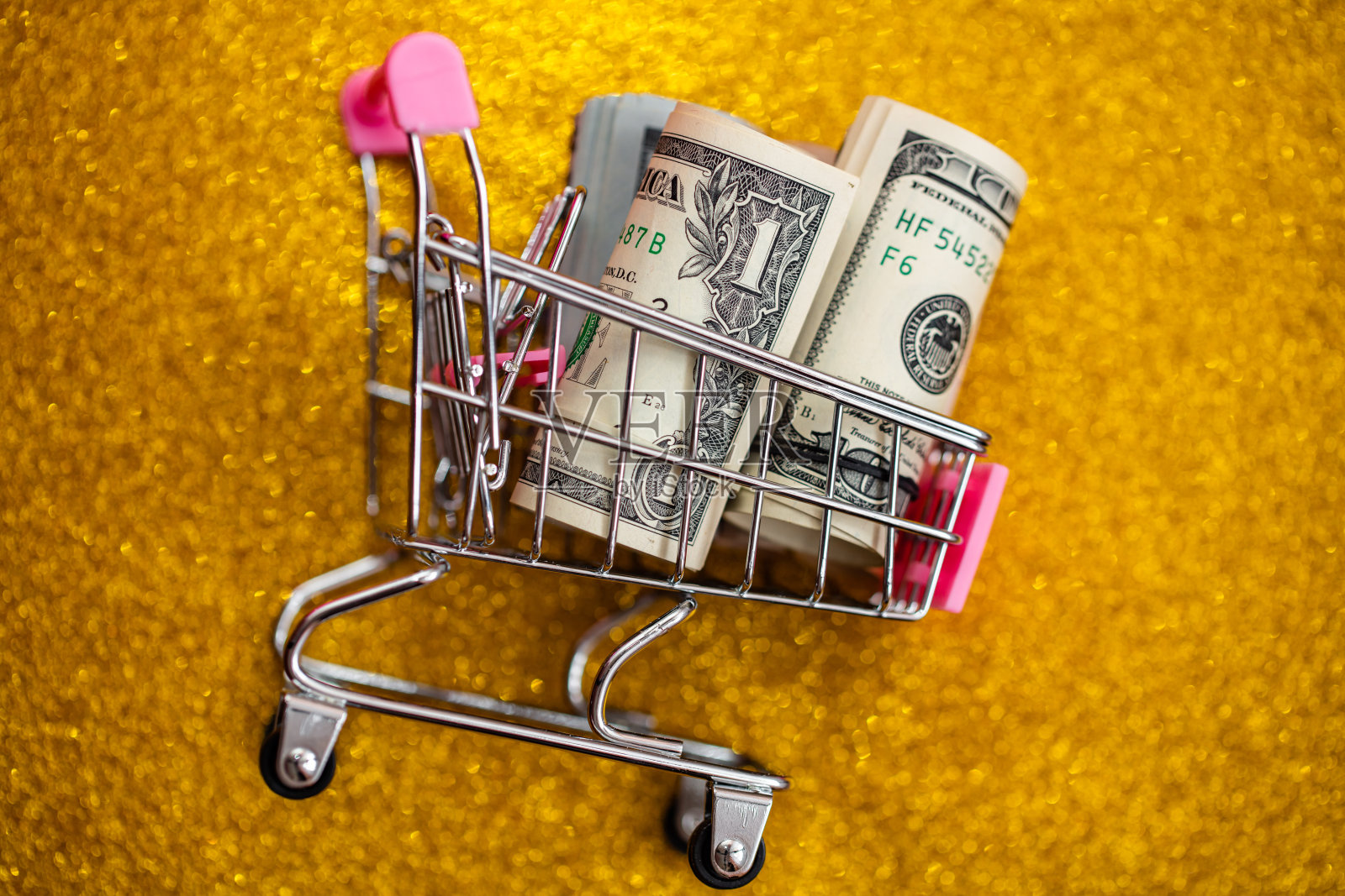 装有100元钞票的小购物车照片摄影图片