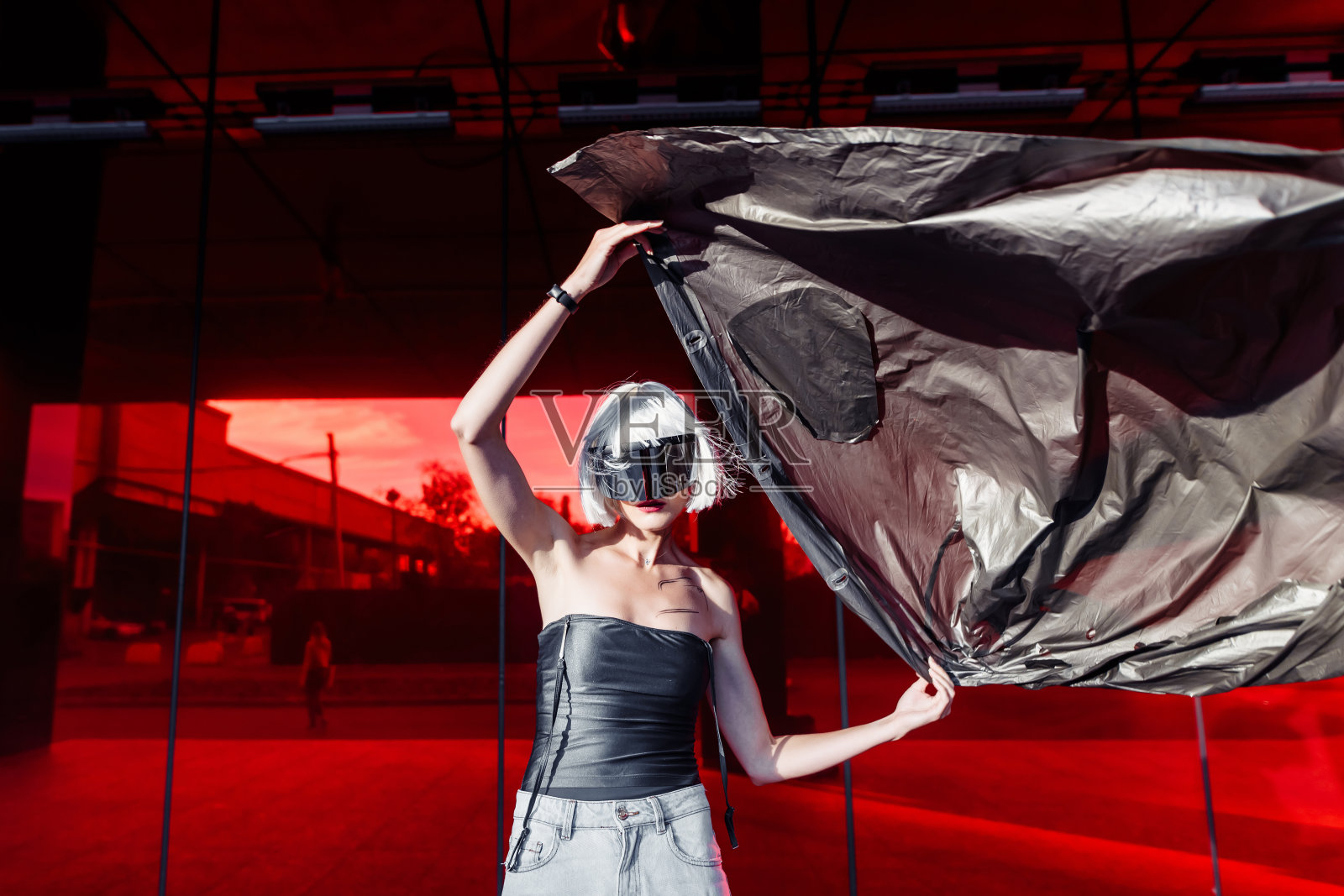 金发，红色背景，穿着时髦的衣服。朋克风格照片摄影图片