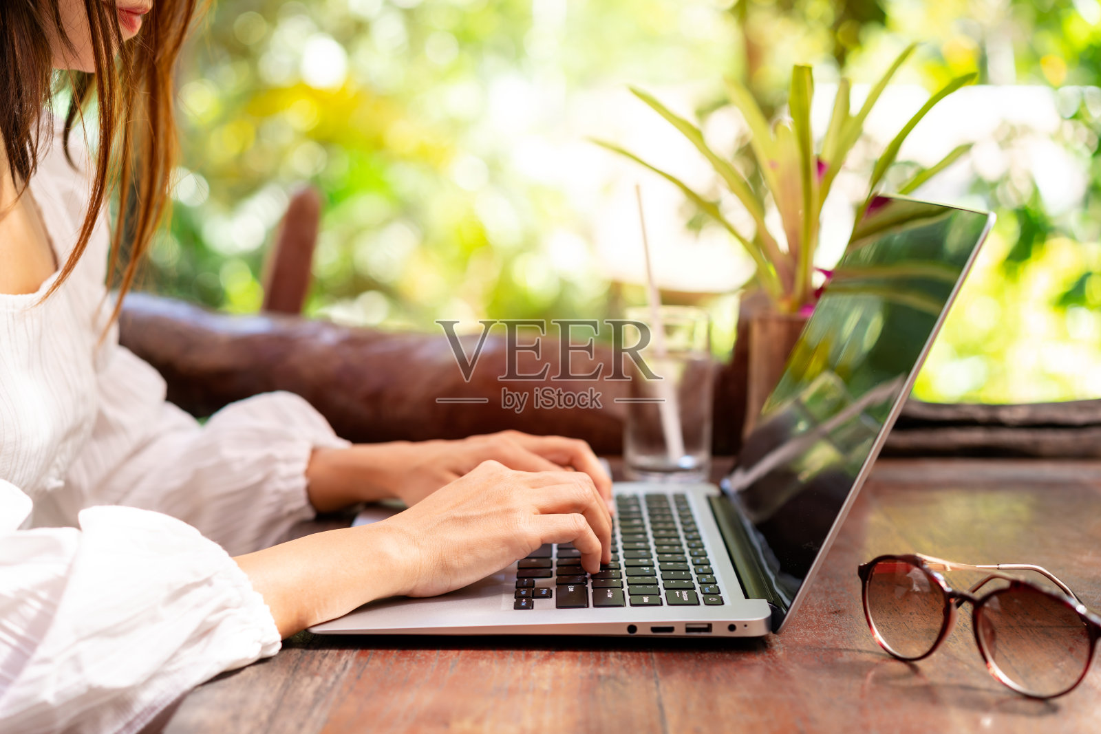 年轻的女性自由职业者旅行者在度假旅行时使用笔记本电脑在线工作，自由职业的概念照片摄影图片