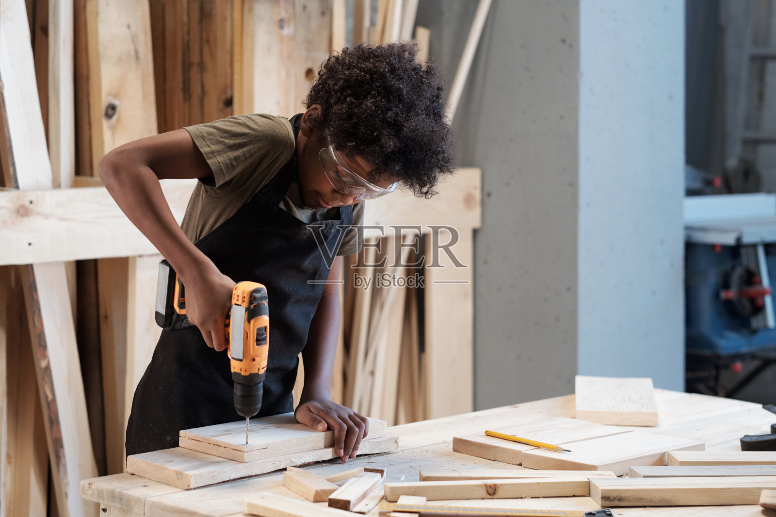 小男孩在木工车间照片摄影图片