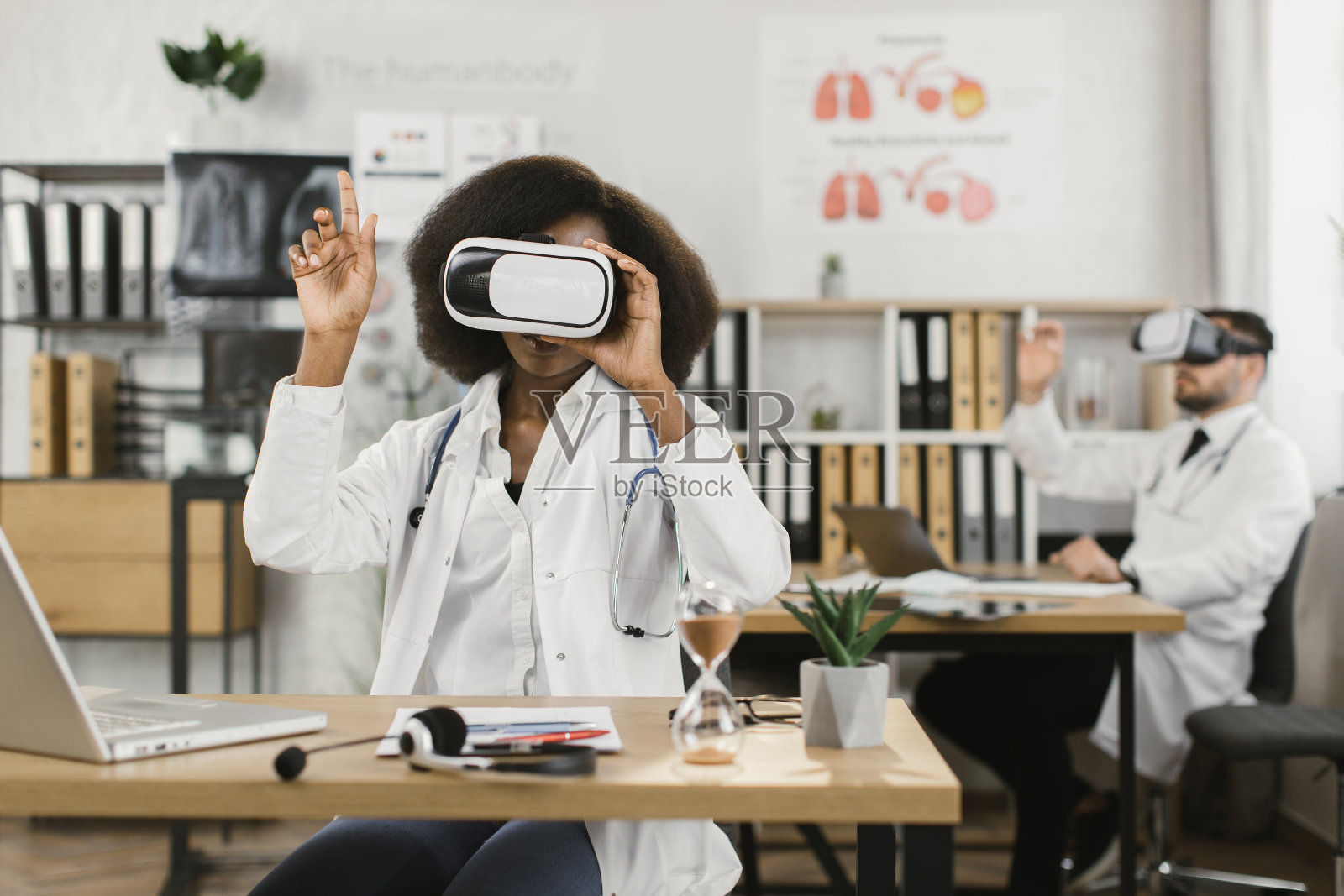 多种族医务工作者戴着VR头盔坐在橱柜前照片摄影图片