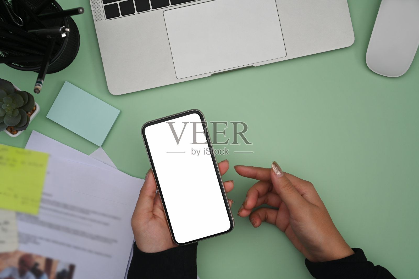 上图中，一位女士坐在富有创造力的工作场所，用着智能手机。照片摄影图片