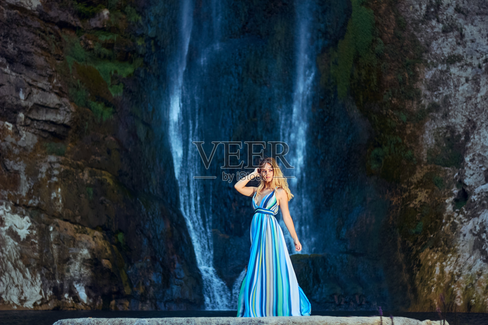 在Bliha瀑布的背景上，年轻的美女穿着长裙照片摄影图片