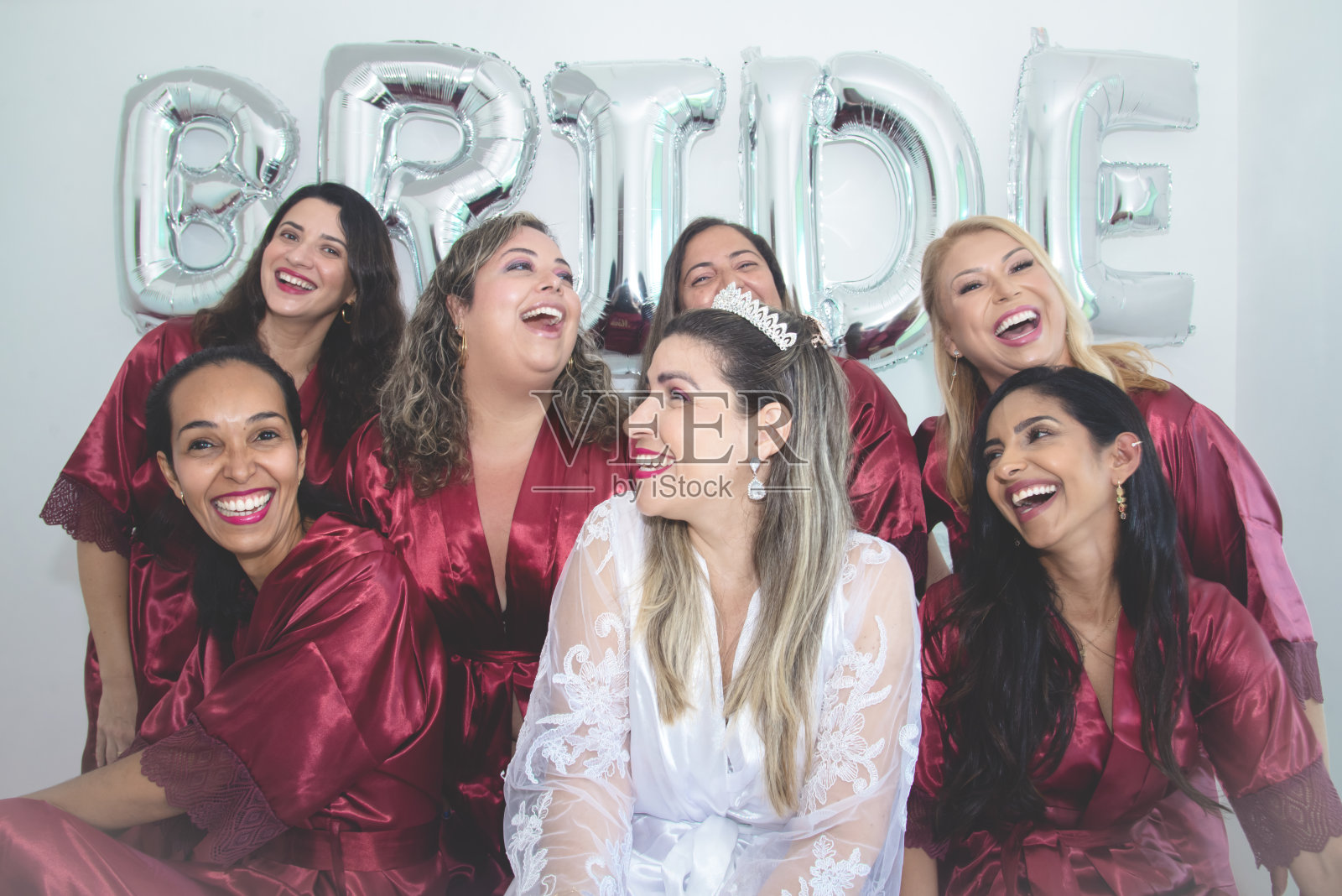 新娘和伴娘一起在白色背景的肖像中写着“新娘”。照片摄影图片