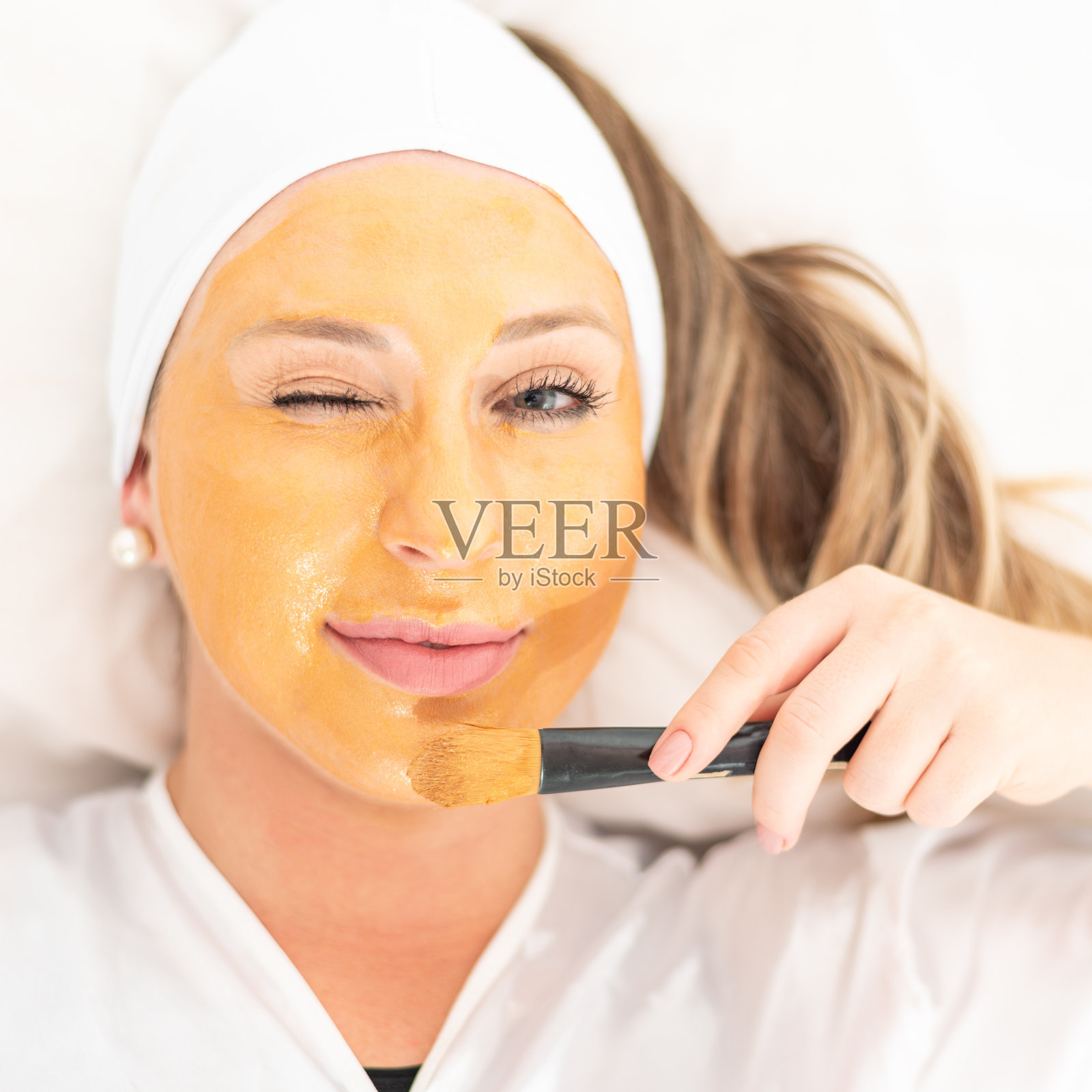 女孩脸上带着美容面膜的特写。照片摄影图片