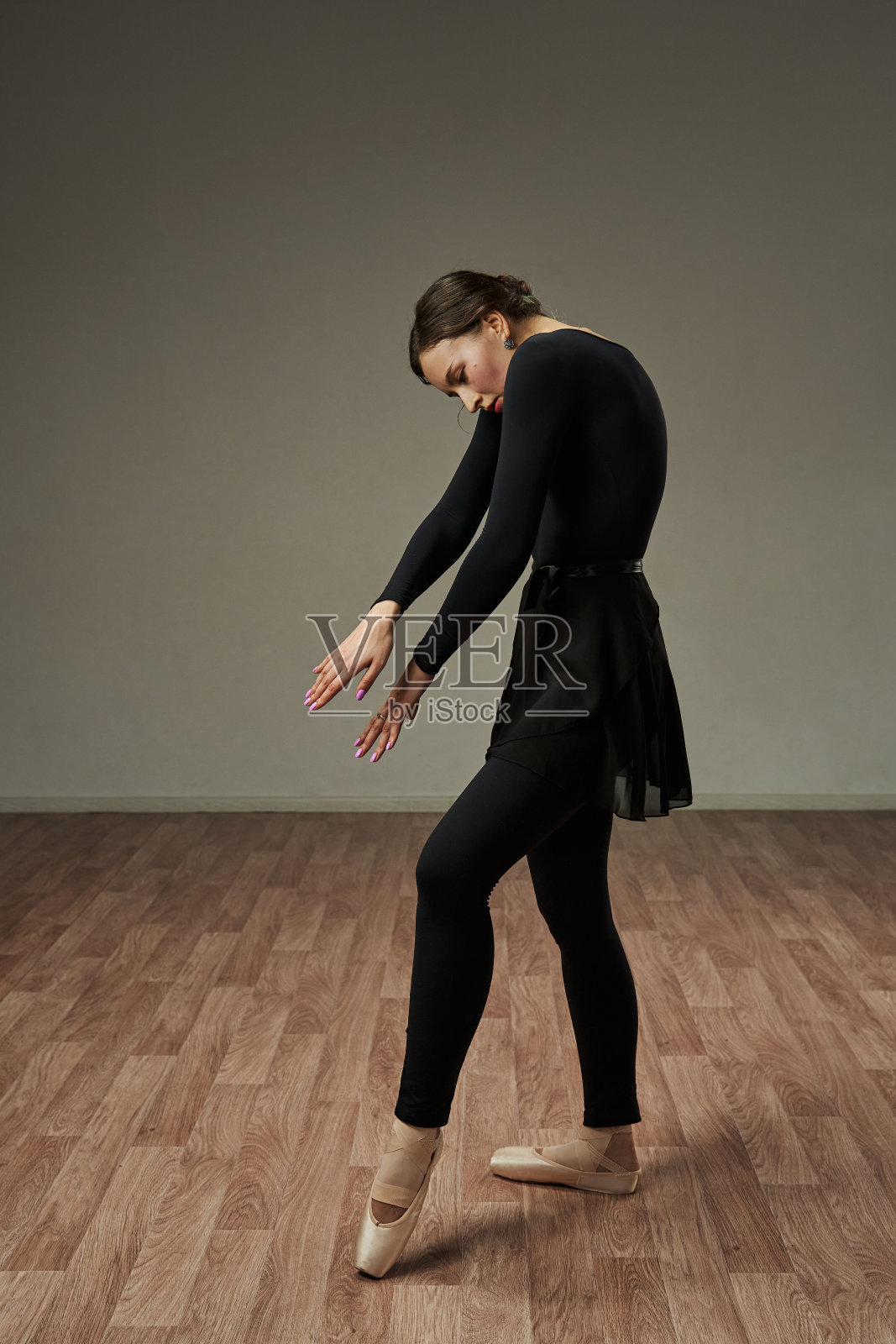 舞蹈演员优雅地摆出一个姿势，双臂交叉放在胸前，背弯着。舞蹈之美与优雅照片摄影图片