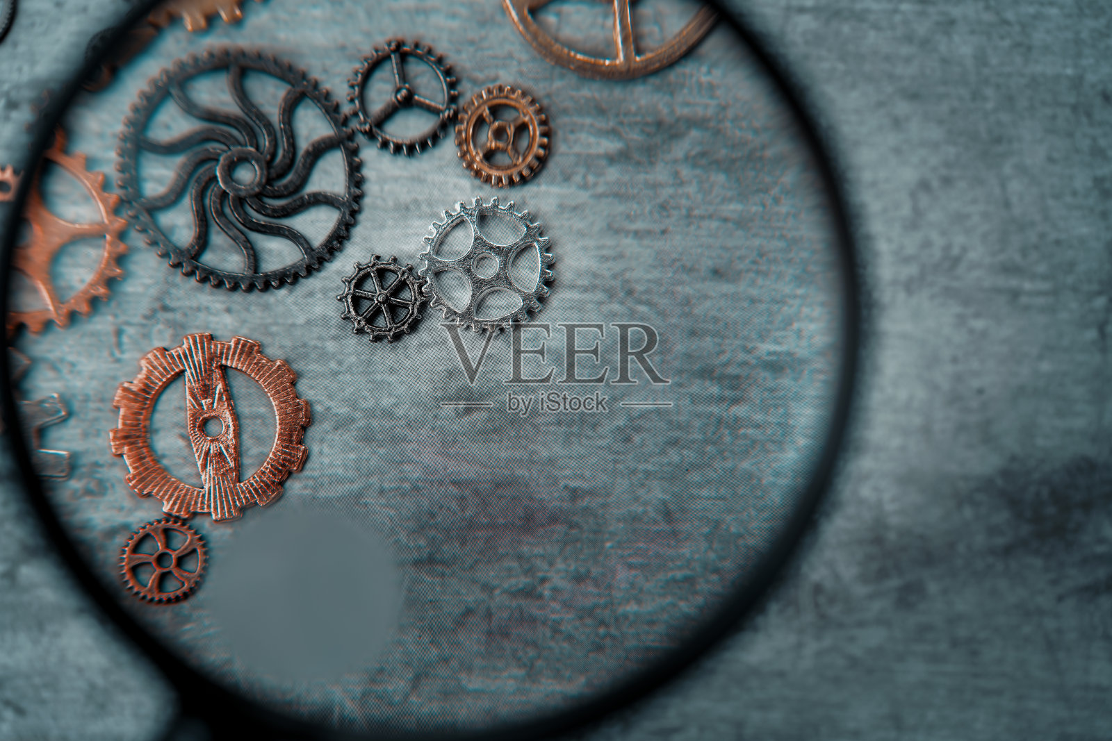 用放大镜看石板上的齿轮照片摄影图片