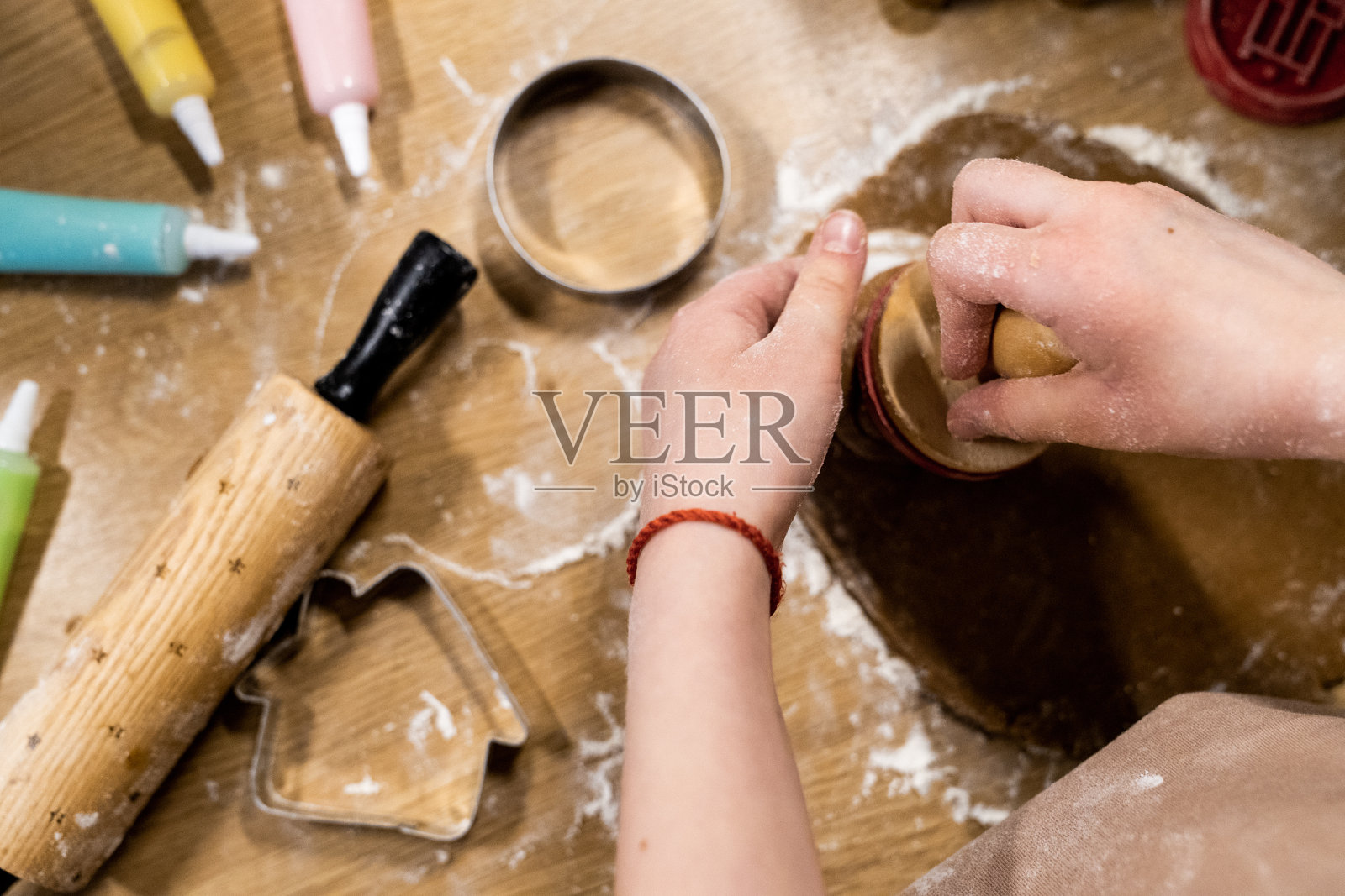 一个孩子在木桌上做自制饼干。照片摄影图片