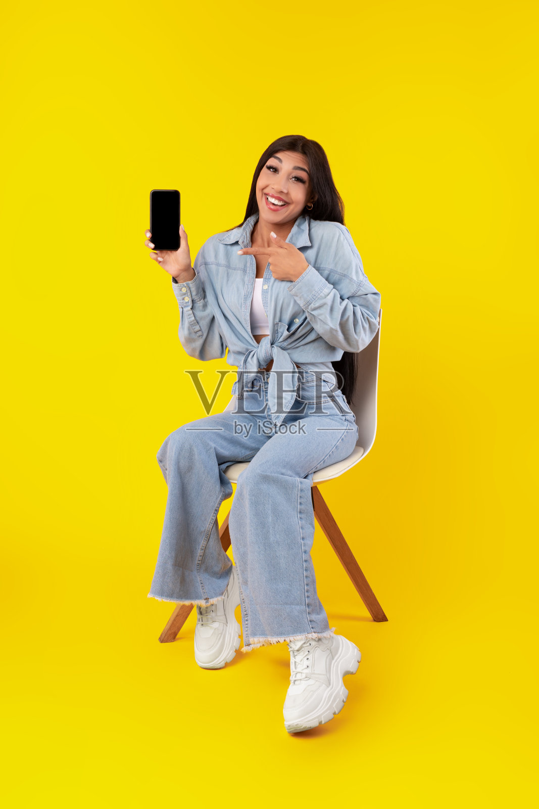 一个女人指着手机屏幕照片摄影图片