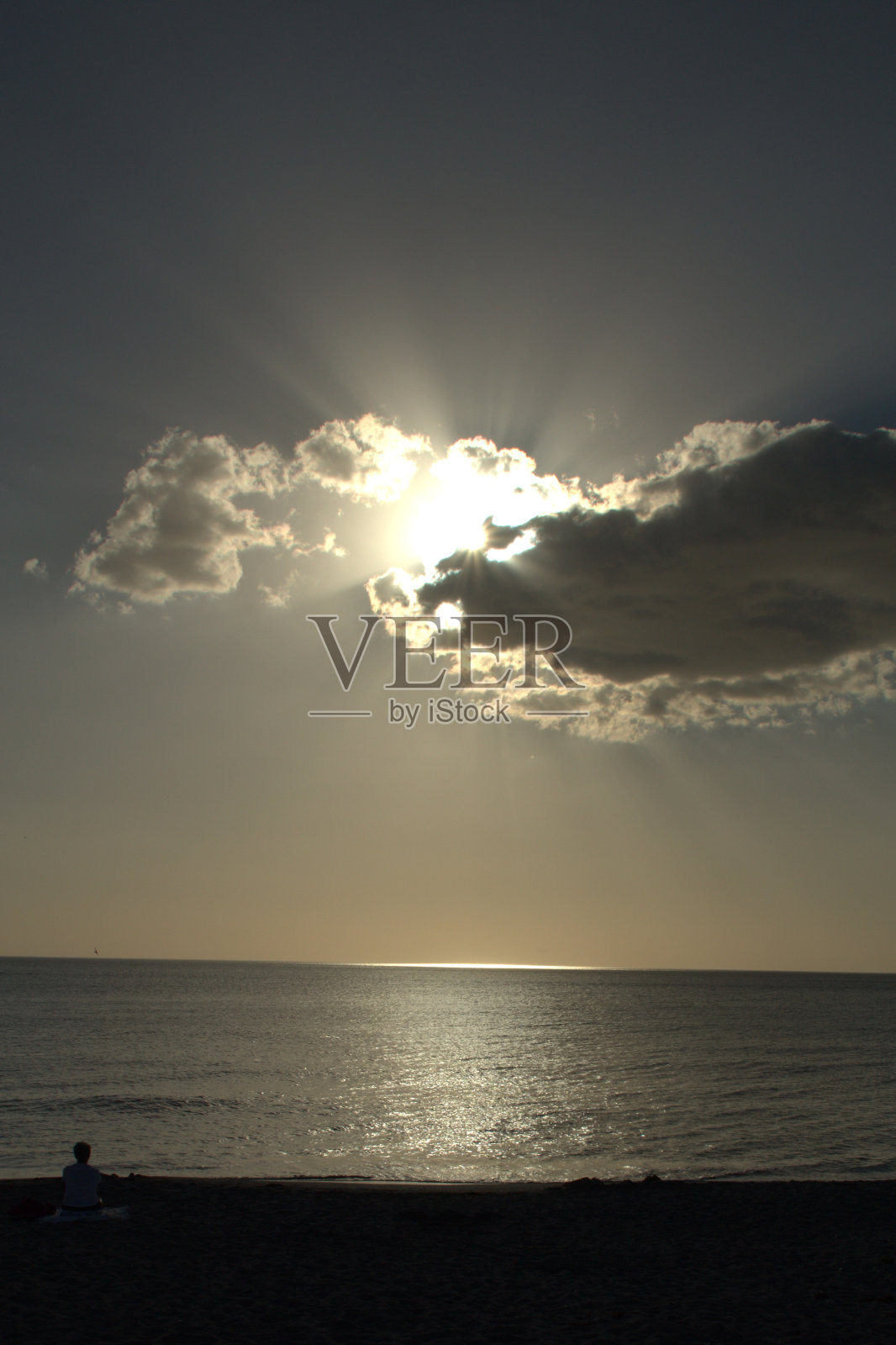 夕阳在远处的云后。照片摄影图片