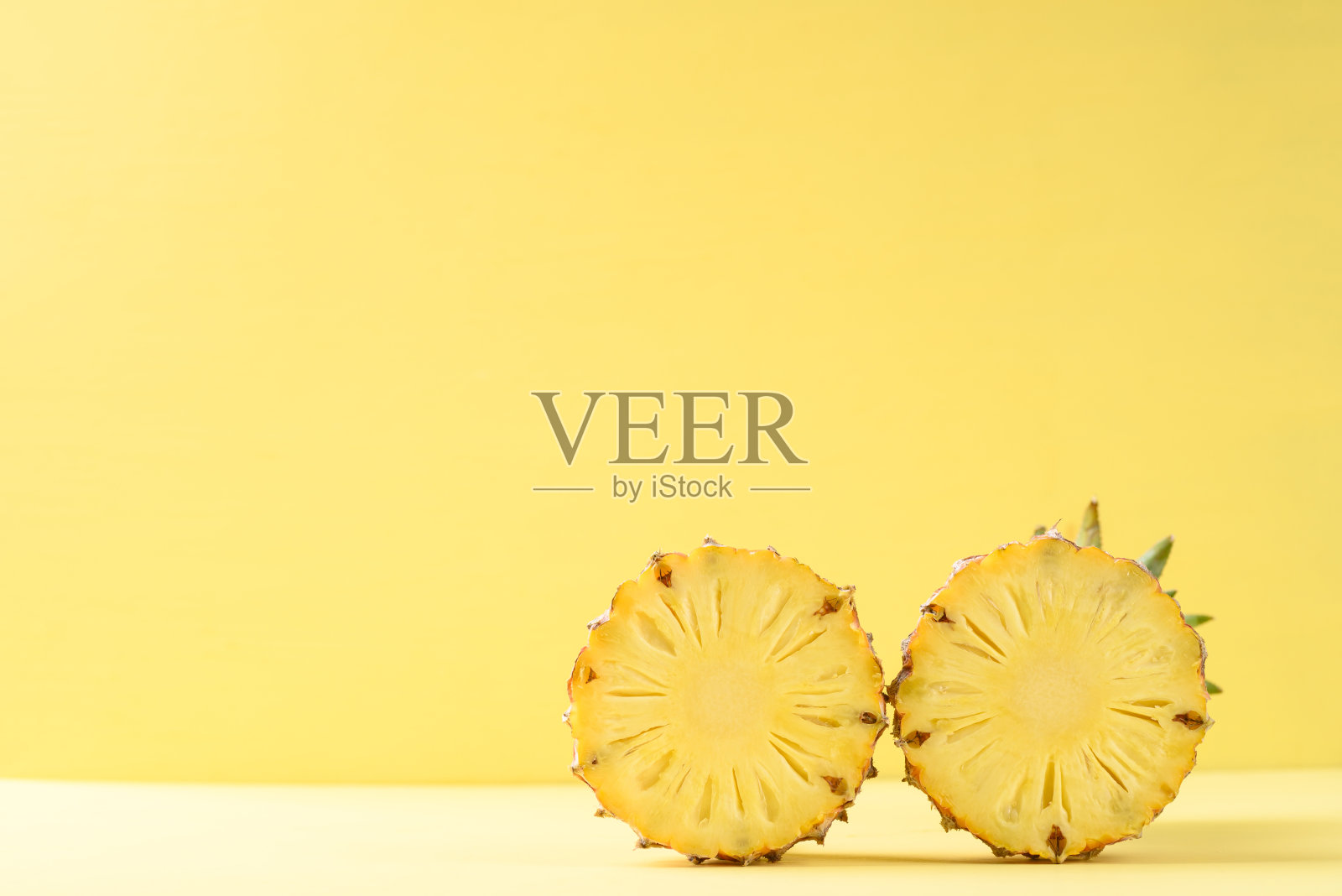 黄色背景上的半个菠萝果照片摄影图片