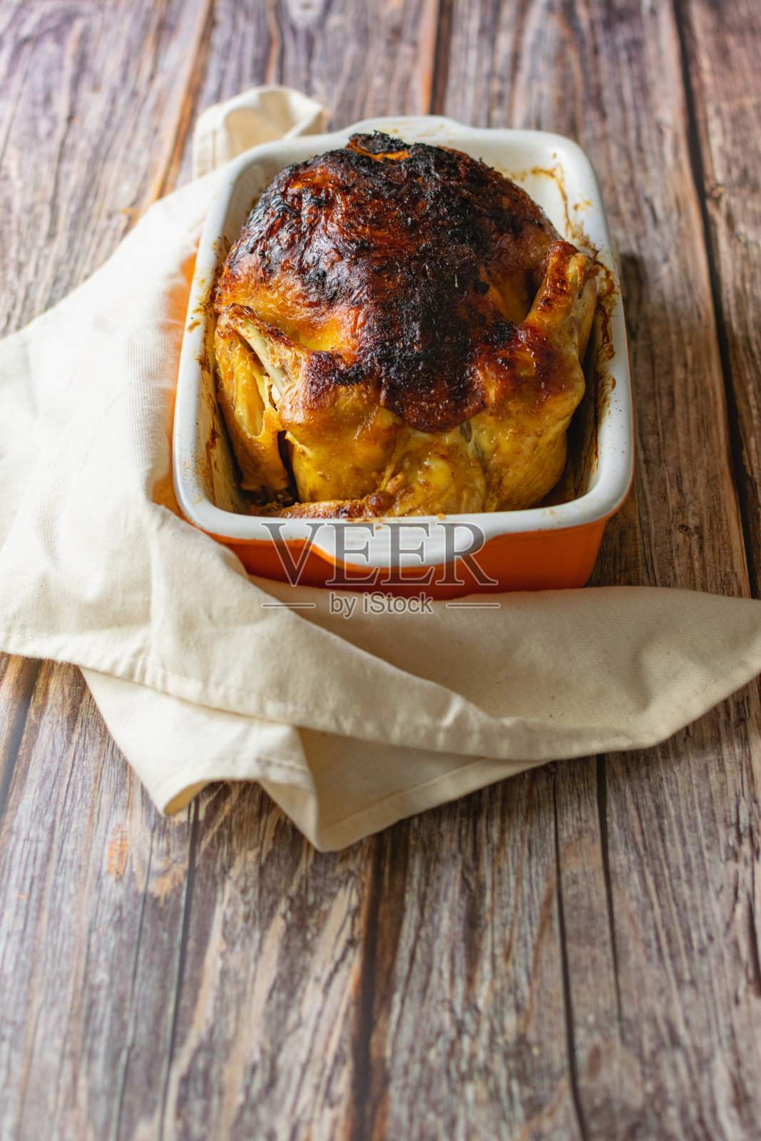 金黄色的烤鸡，表皮酥脆，在深色的背景上，是家庭晚餐的开胃菜，美味的油炸食品照片摄影图片