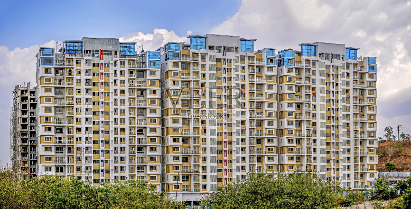 马哈拉施特拉邦浦那，色彩鲜艳的高楼正在建设中，背景是清澈的蓝天。照片摄影图片