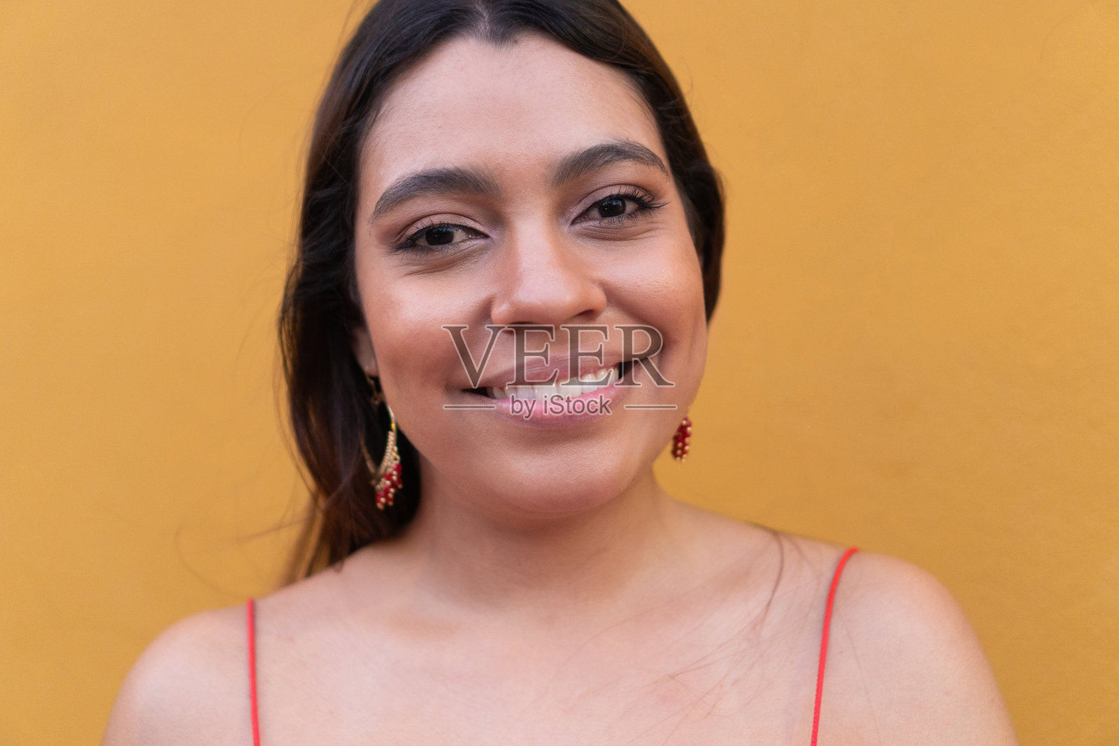 黄色背景上一个微笑的女人的肖像。照片摄影图片