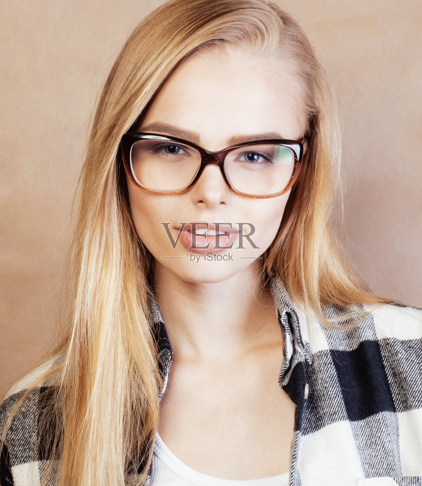 年轻漂亮的女孩十几岁，戴着眼镜在学校自拍，背着背包的学生，生活方式和人的概念照片摄影图片