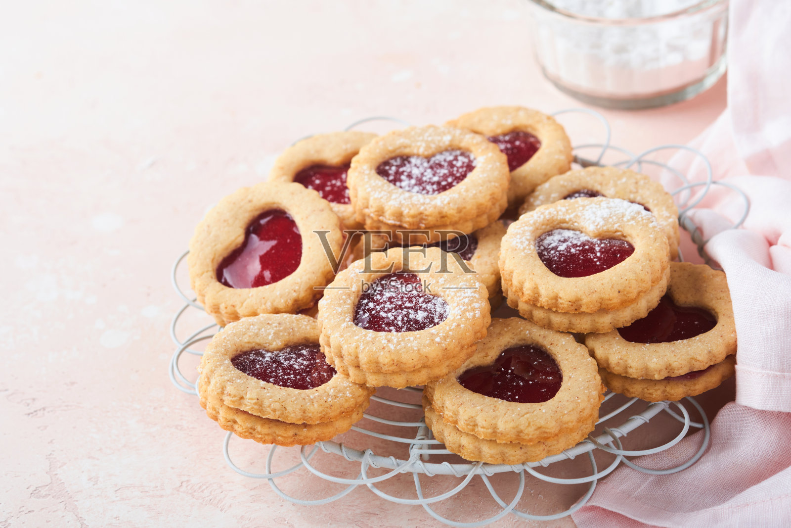 传统的林泽饼干，草莓酱和糖粉，粉红色的美丽背景。前视图。传统的奥地利自制甜点情人节。节日点心的概念。照片摄影图片